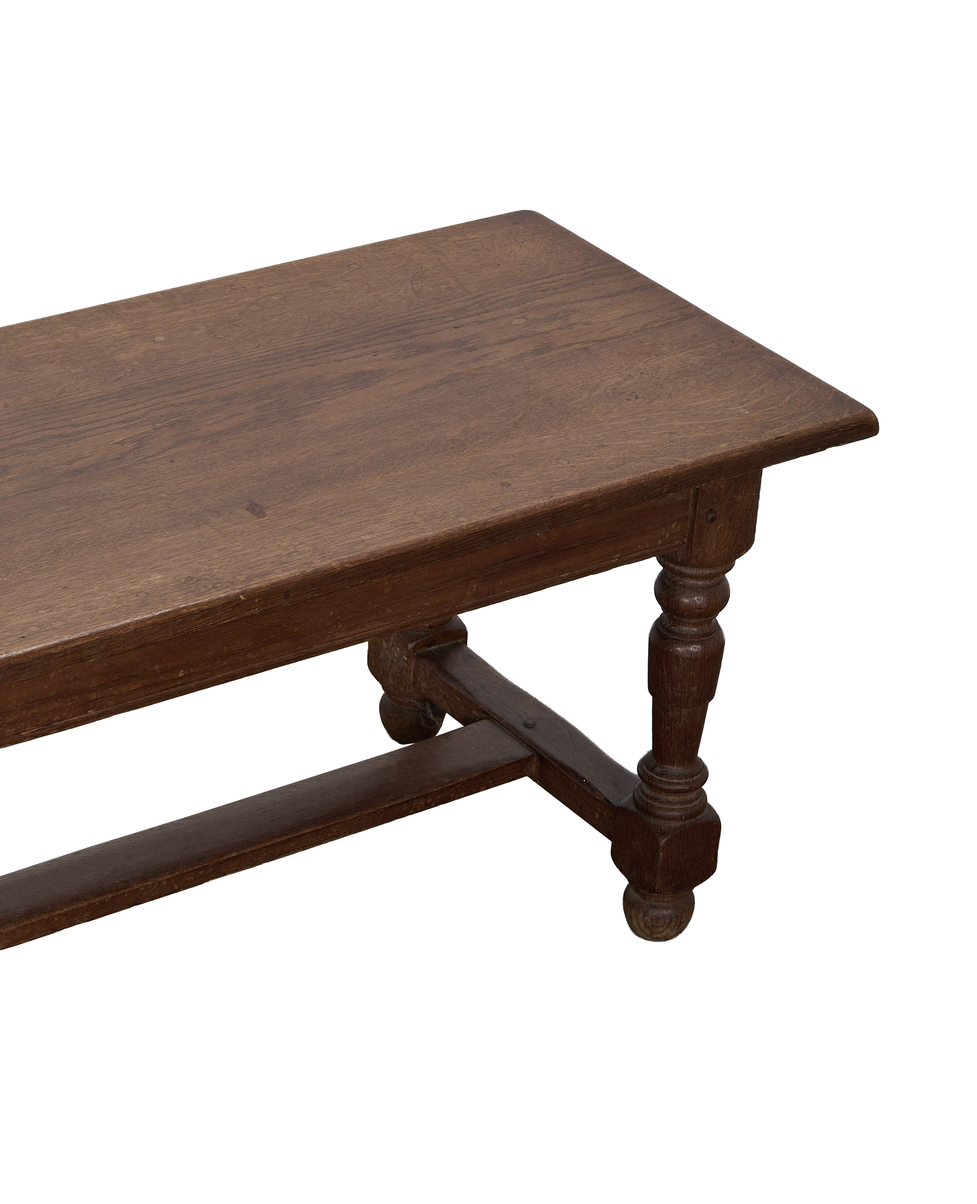 Vintage French oak coffee table with ornate turned legs and stretcher, showing aged details.