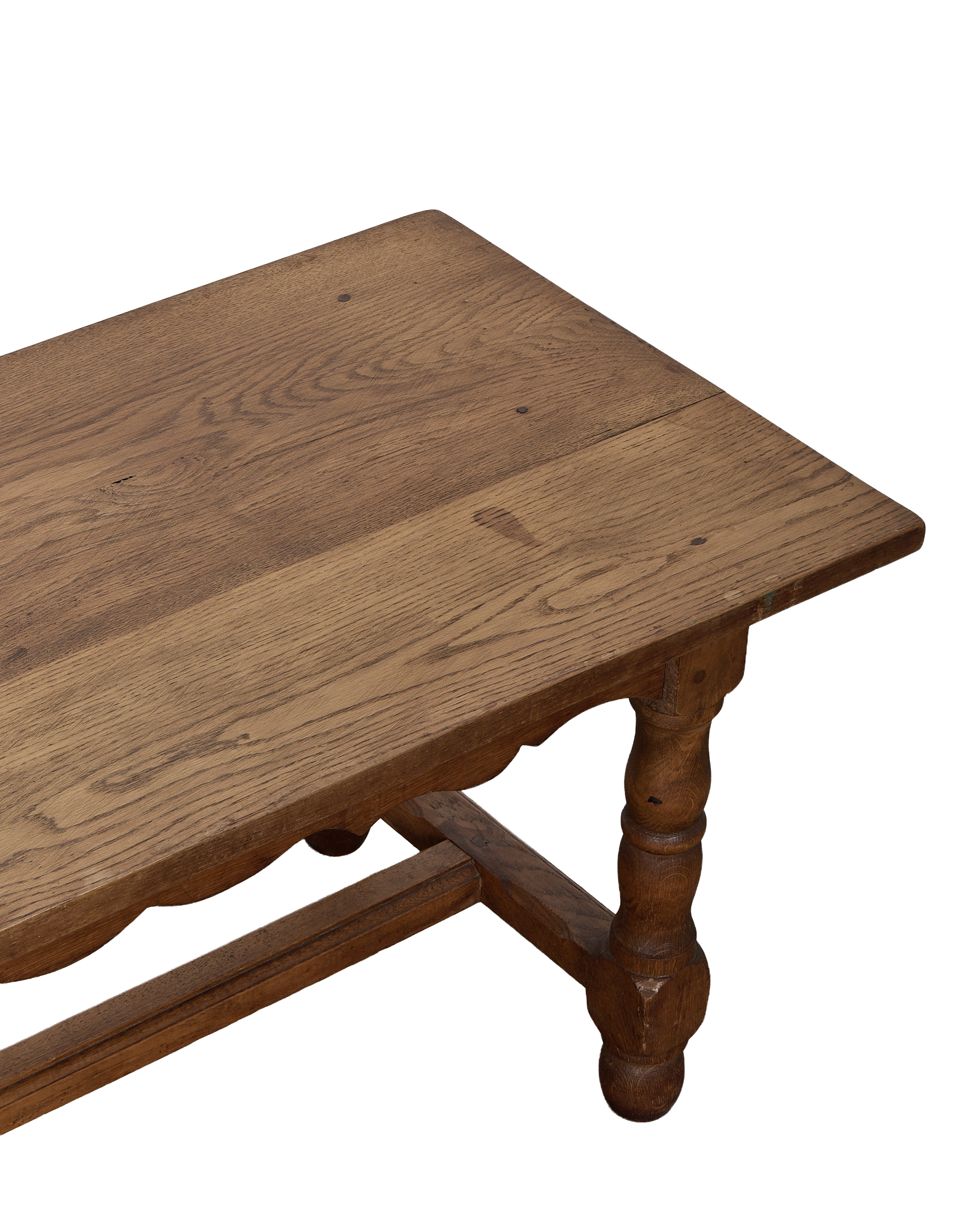 Vintage French oak coffee table showcasing its rustic top surface and carved leg detail.
