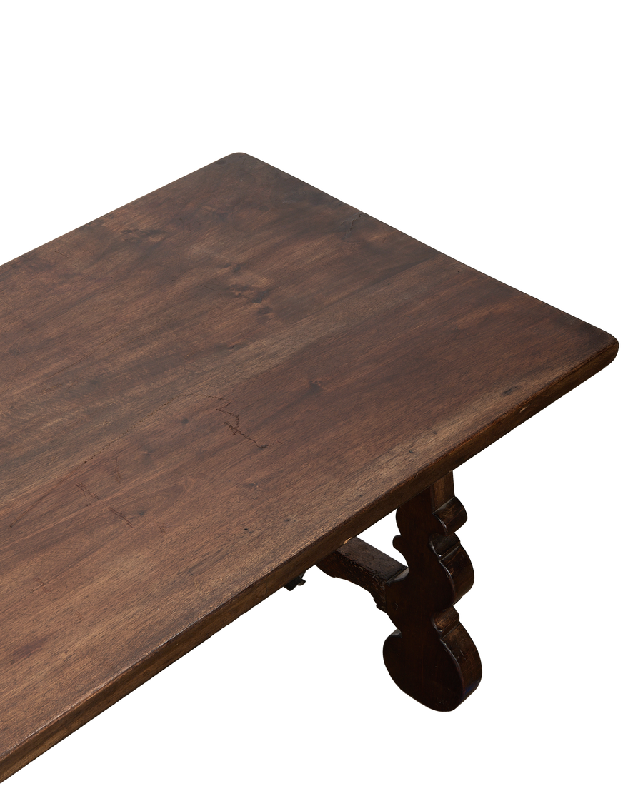 Vintage French oak refectory coffee table top, showing distressed wood grain and curved leg detail.