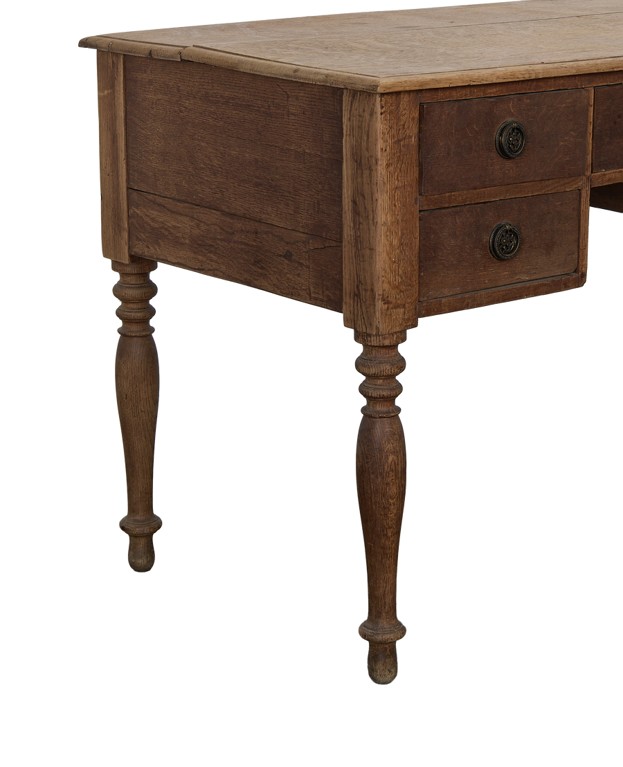 Vintage French oak desk, close-up of aged wood, ornate drawer pull, turned leg.