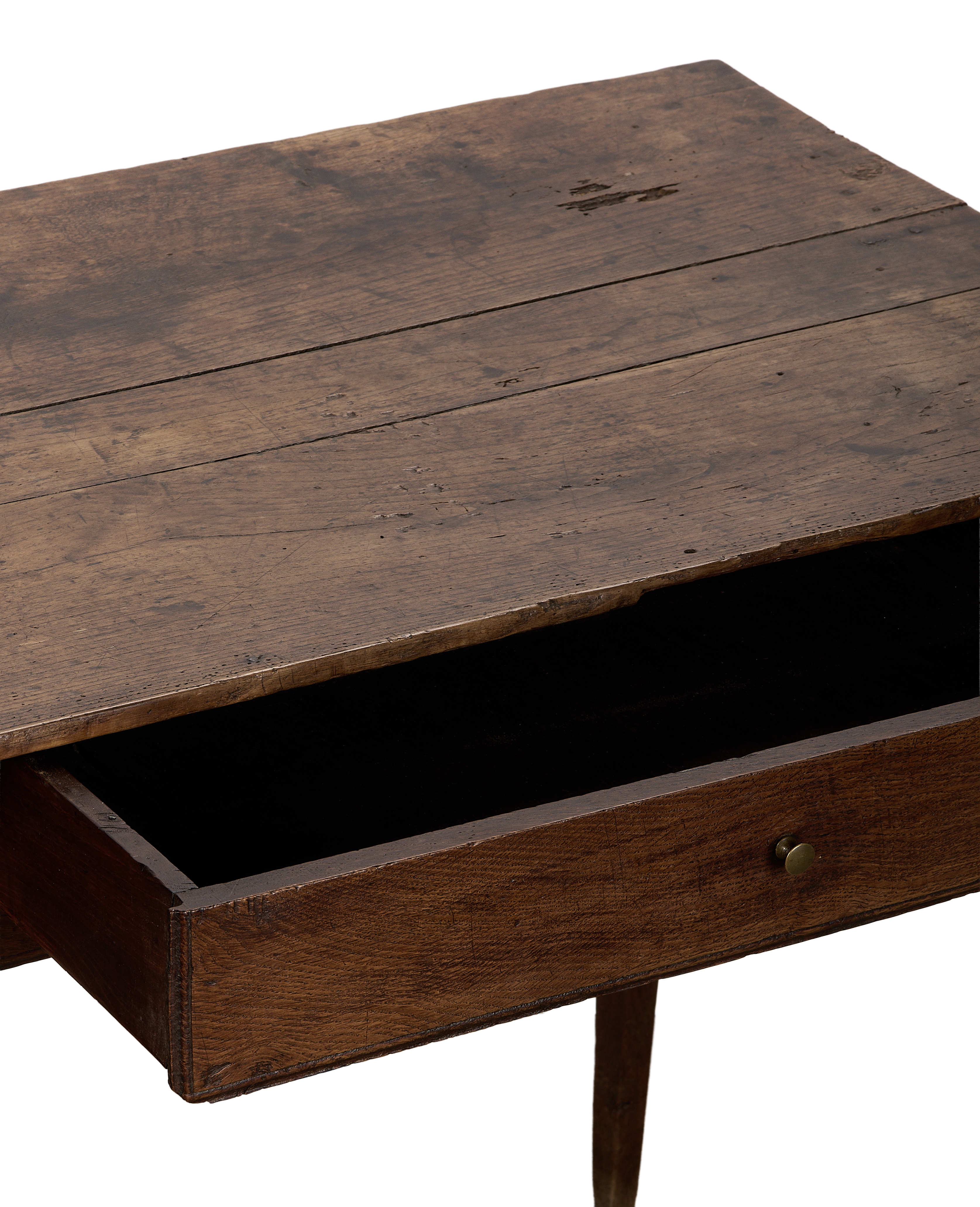 Vintage French oak wood desk drawer, partially open, revealing aged patina and brass knob.