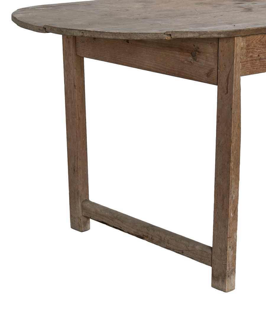 Vintage oak oval French dining table, showing rough wood texture and sturdy leg joinery.