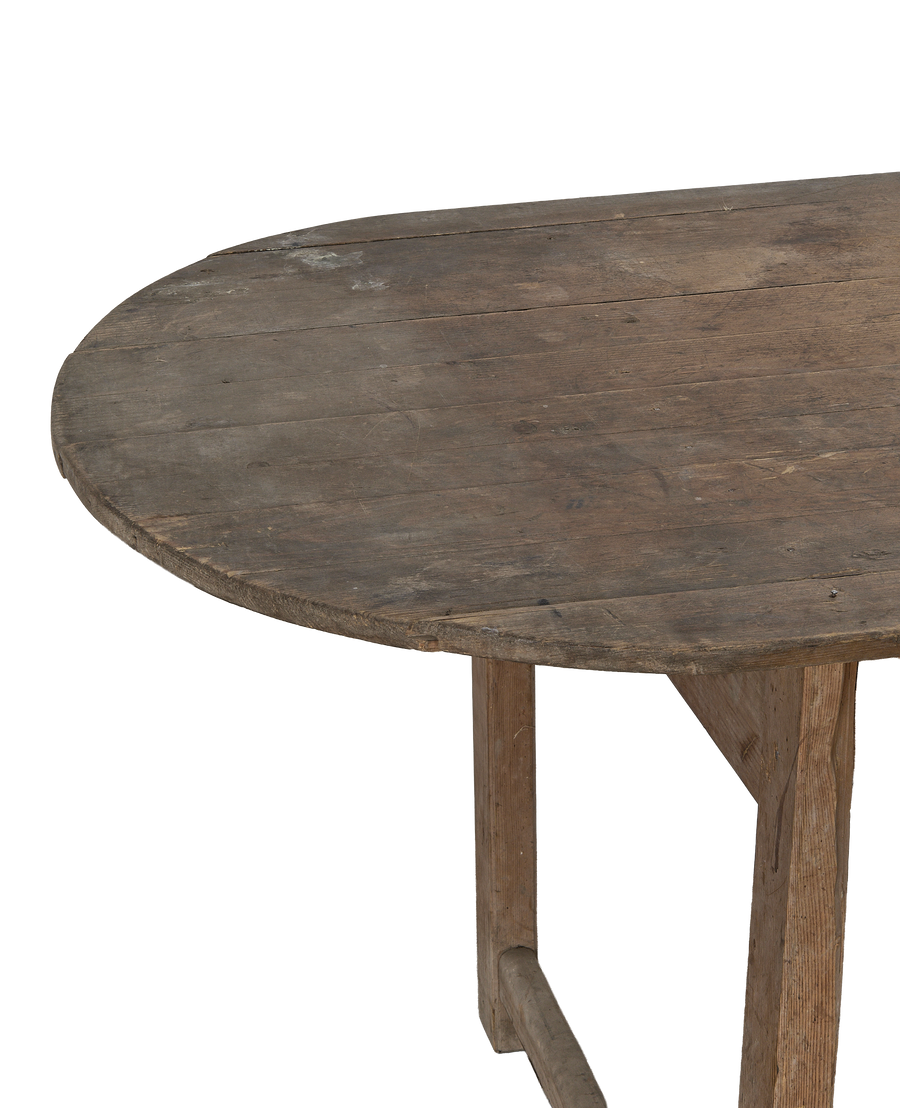 Vintage French oval oak dining table, detailed top view of rustic wood grain.