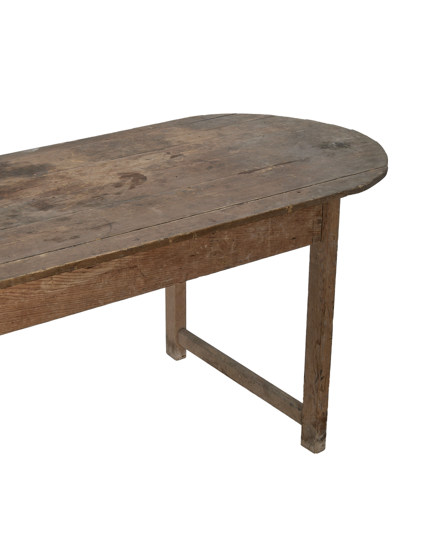 Vintage French oval oak dining table showing rustic plank top and sturdy aged legs.