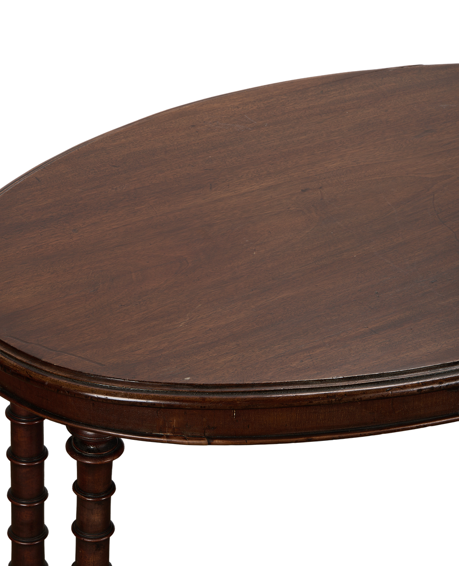 Vintage French oval oak entry table, detailed close-up of dark wood top and turned legs.