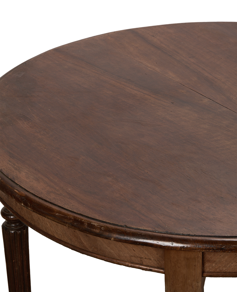 Vintage oak round dining table surface, close-up of dark wood grain with seam.