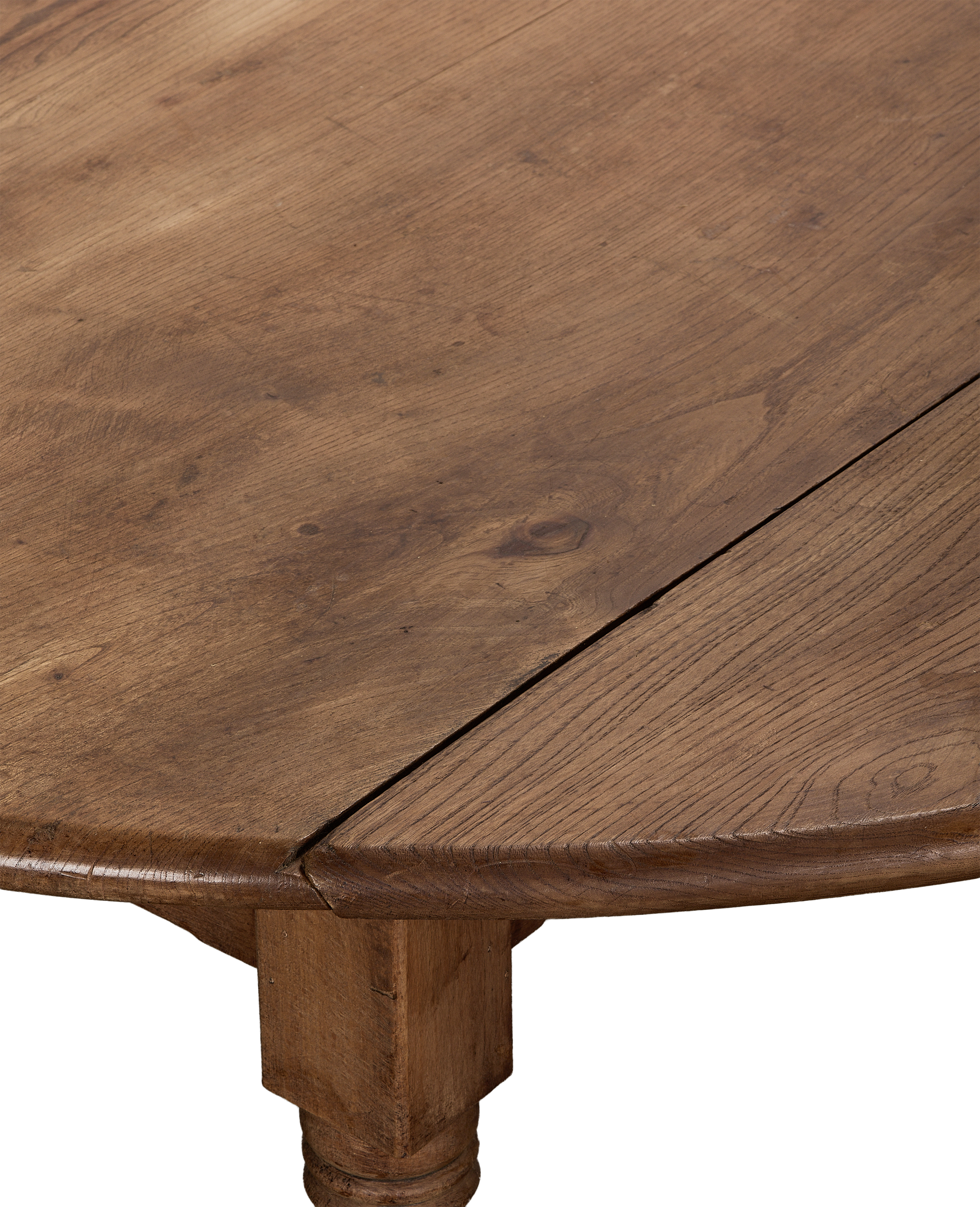 Close-up of vintage French oak drop leaf table's aged wood grain and joinery.