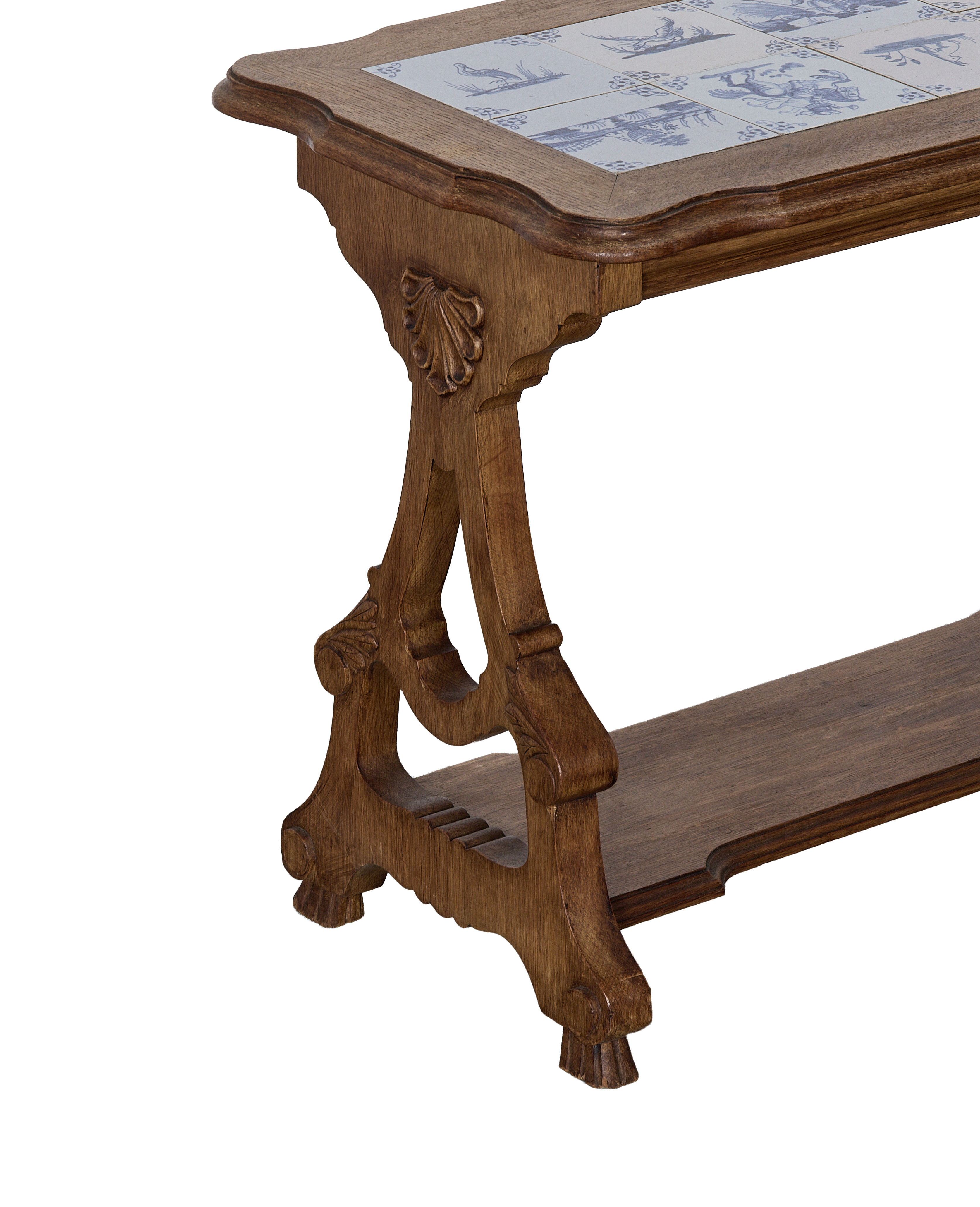 Vintage French oak table leg with shell carving, lower shelf, and Delft tile detail.