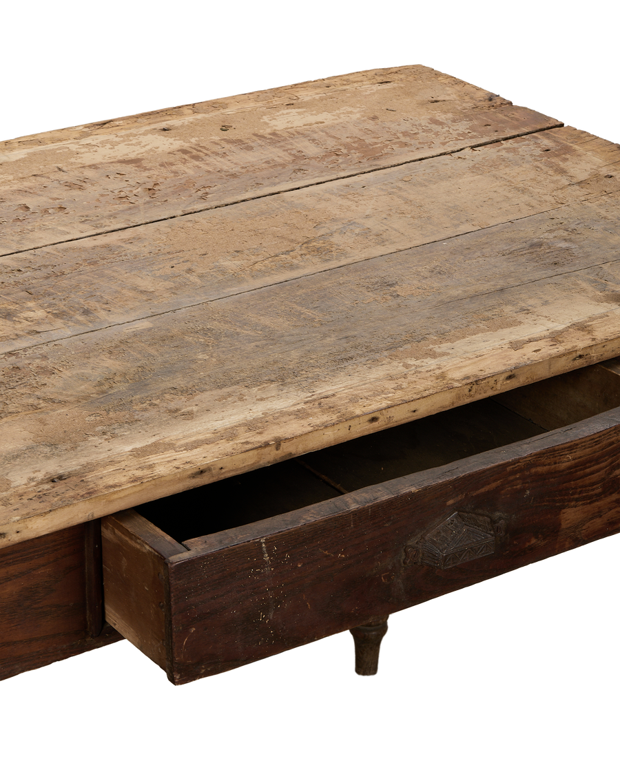 Vintage French oak farm table, showing distressed wooden top and partially opened drawer.
