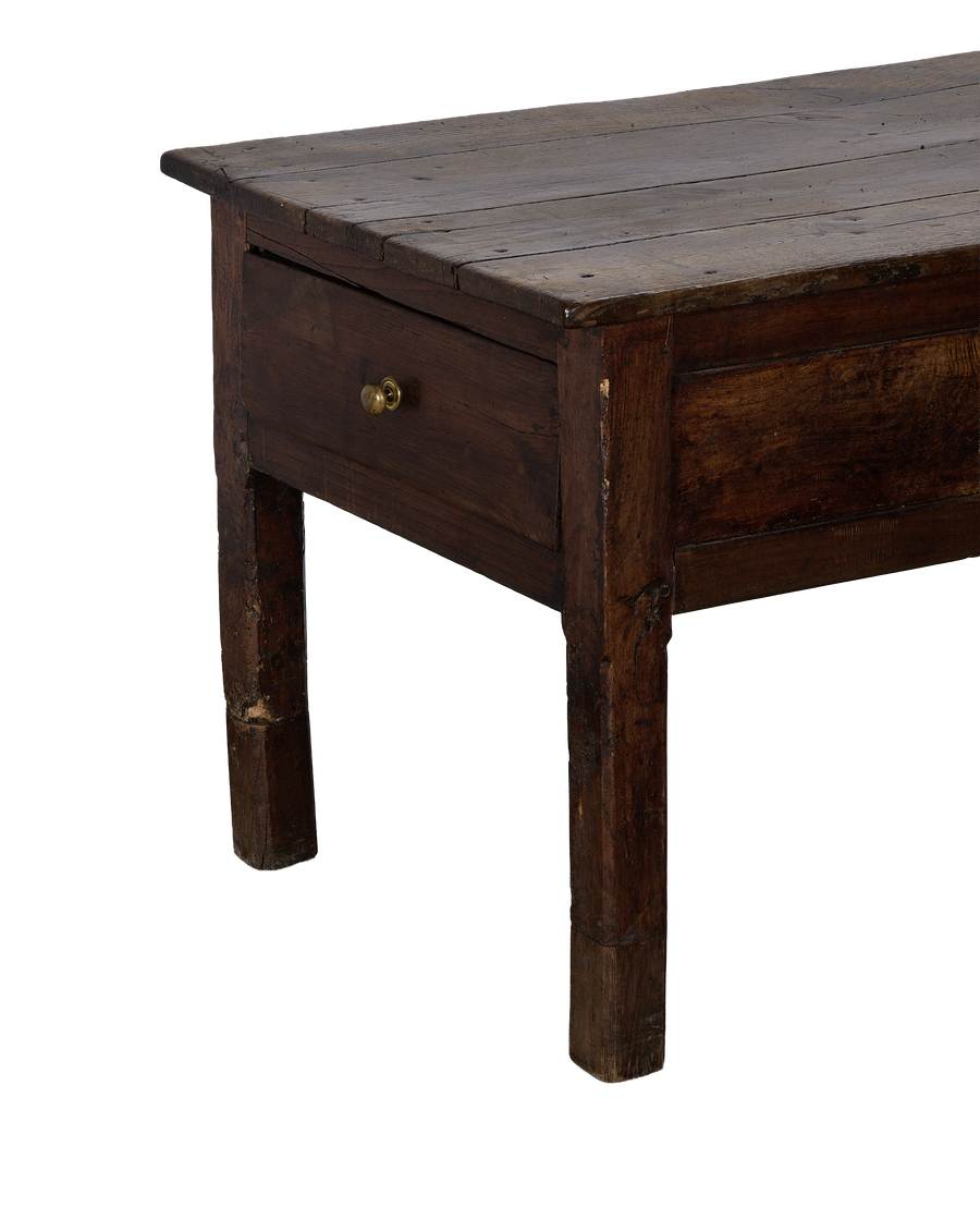 Side angle of vintage French oak drawer table showing brass pull and distressed wood.