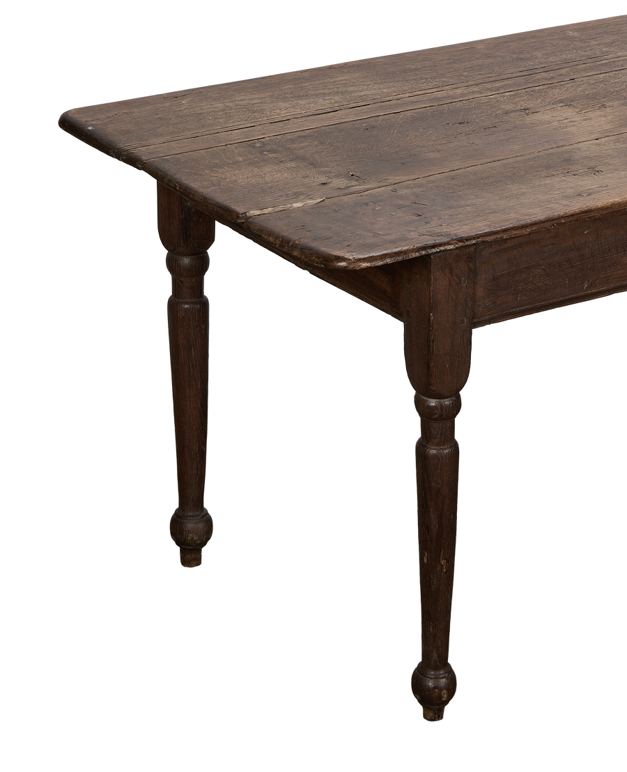 Vintage French oak farm table, showing the dark, rustic tabletop texture and turned legs.