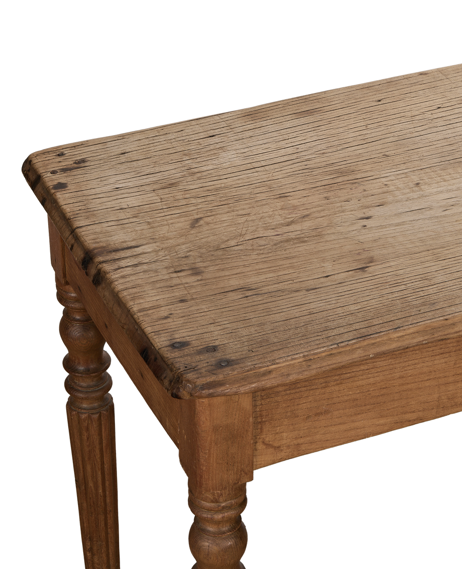 Vintage French oak farm table, close-up of distressed rustic wood tabletop detail with round legs.