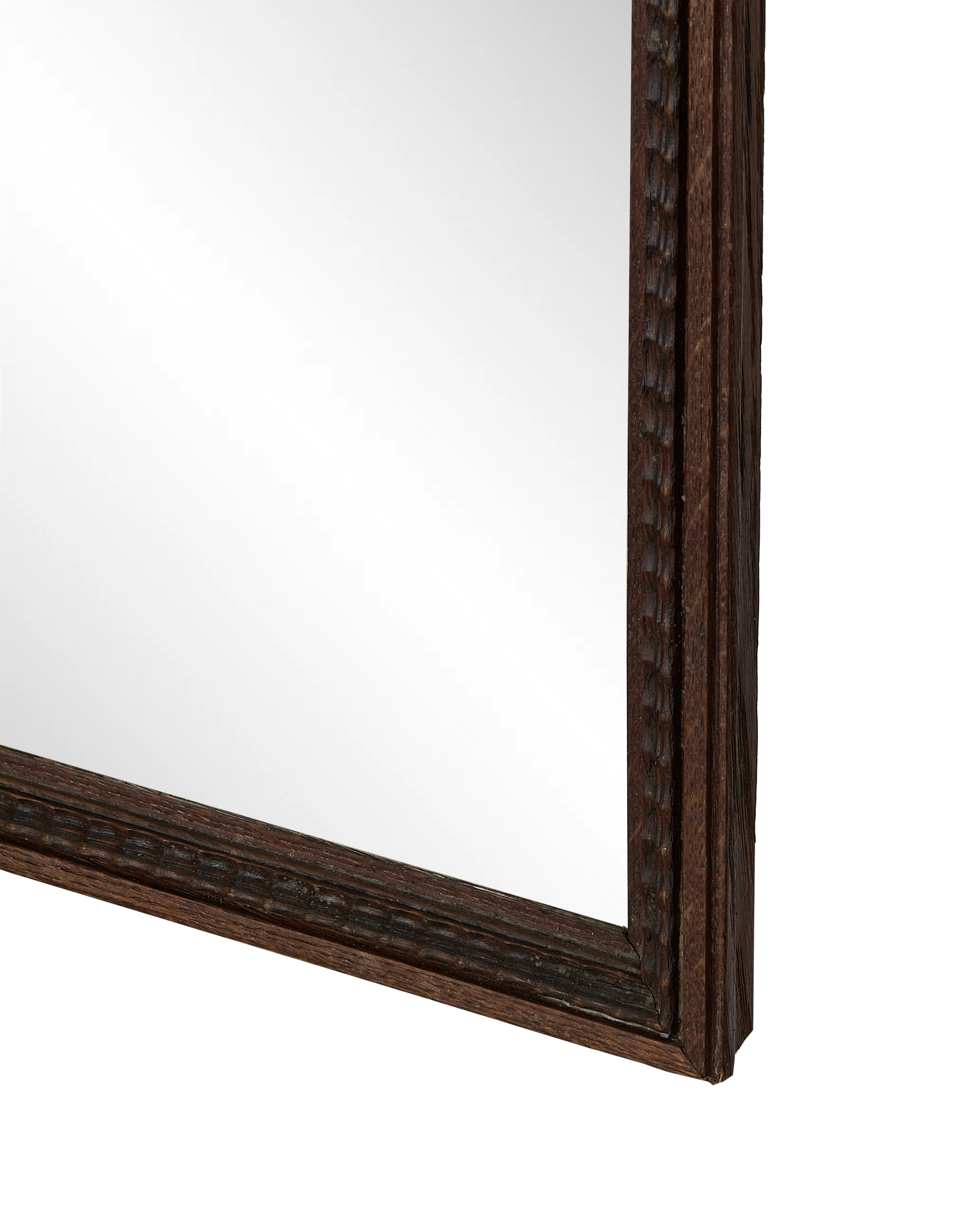 Close-up of vintage French carved oak mirror frame showing textured wood grain.