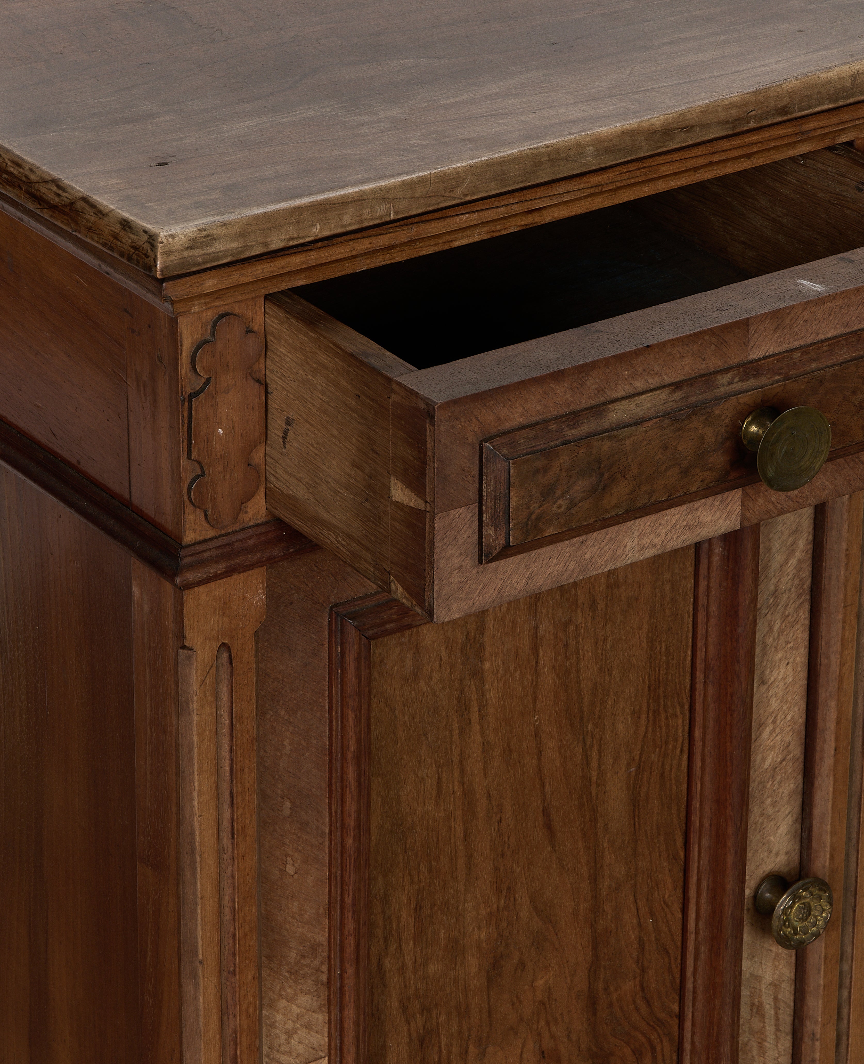 Vintage French oak nightstand, drawer open, showing dovetail joint construction and worn brass knob.