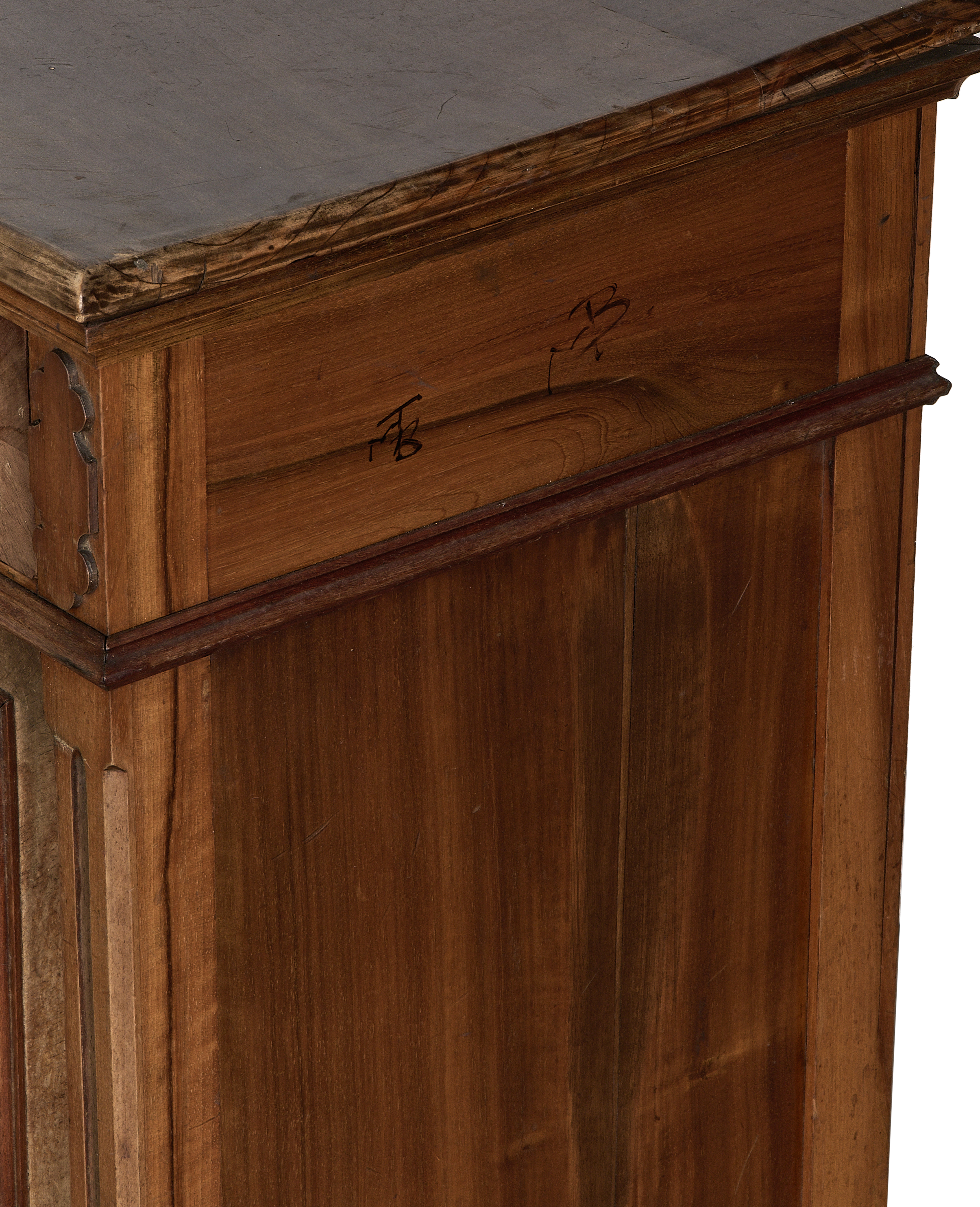 Vintage French oak nightstand: close-up of decorative carved wood corner and dark distressed top.