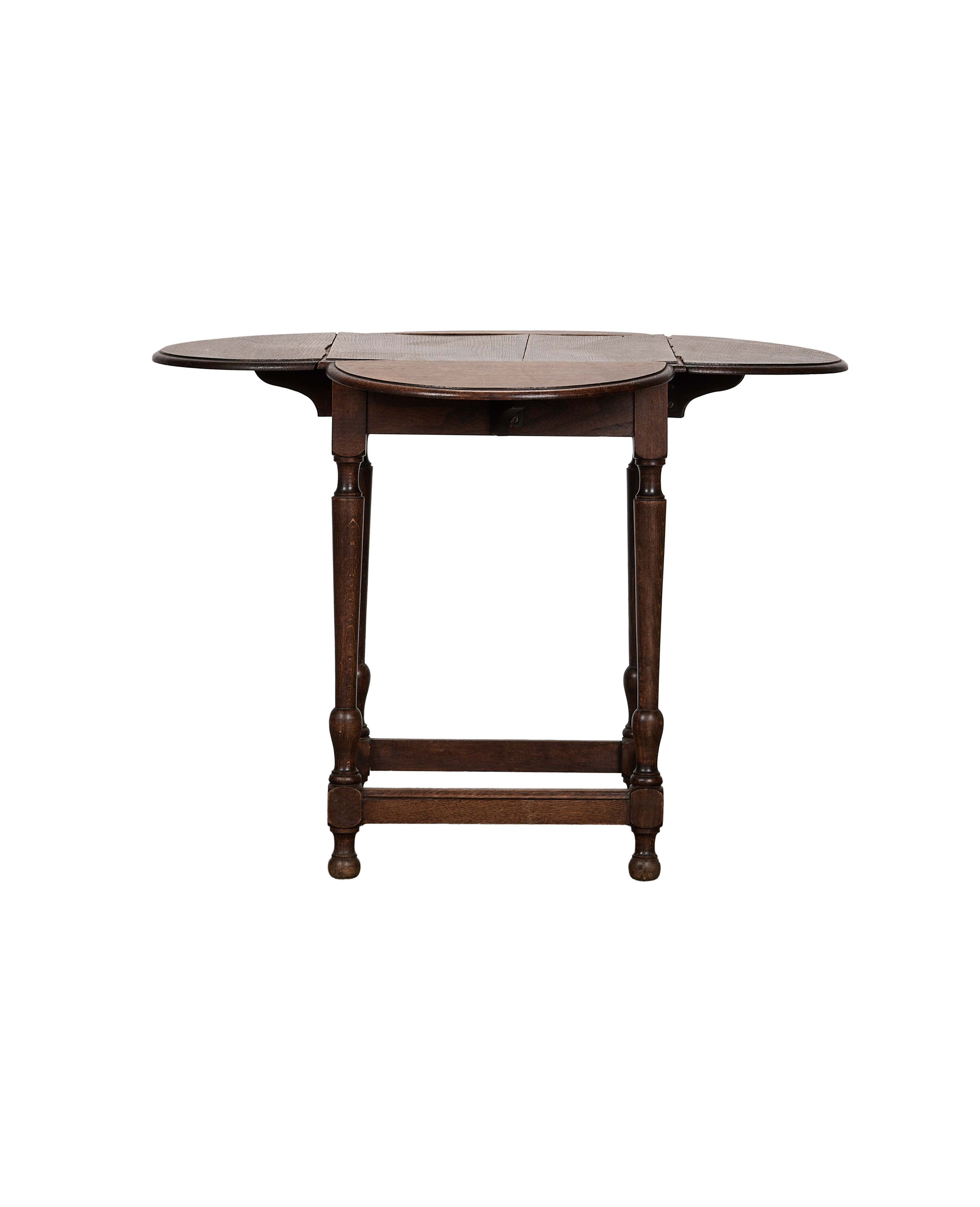 Vintage French oak drop leaf table, leaves extended, showing turned legs and feet.