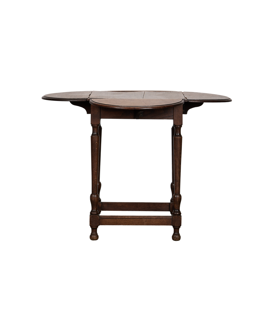 Vintage French oak drop leaf table, leaves extended, showing turned legs and feet.