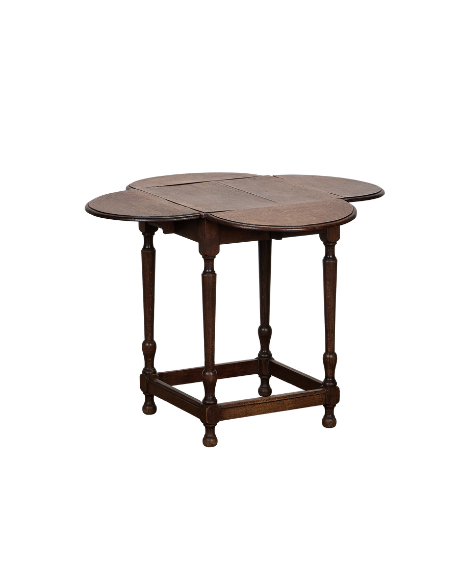 Vintage French oak clover drop leaf table, partially open, showcasing turned legs and stretcher base.