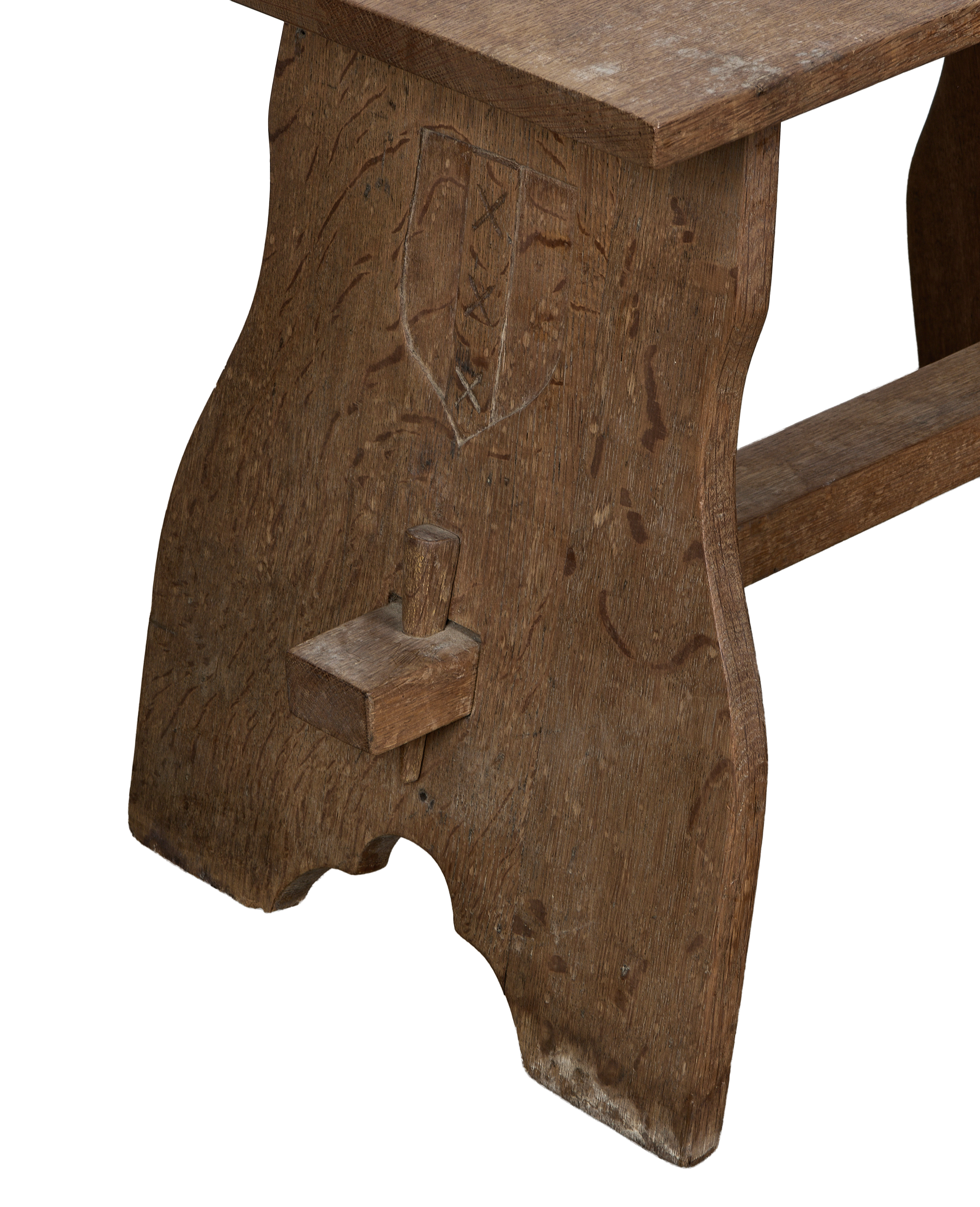 Vintage French oak church stool, close-up of side leg with carved shield detail.