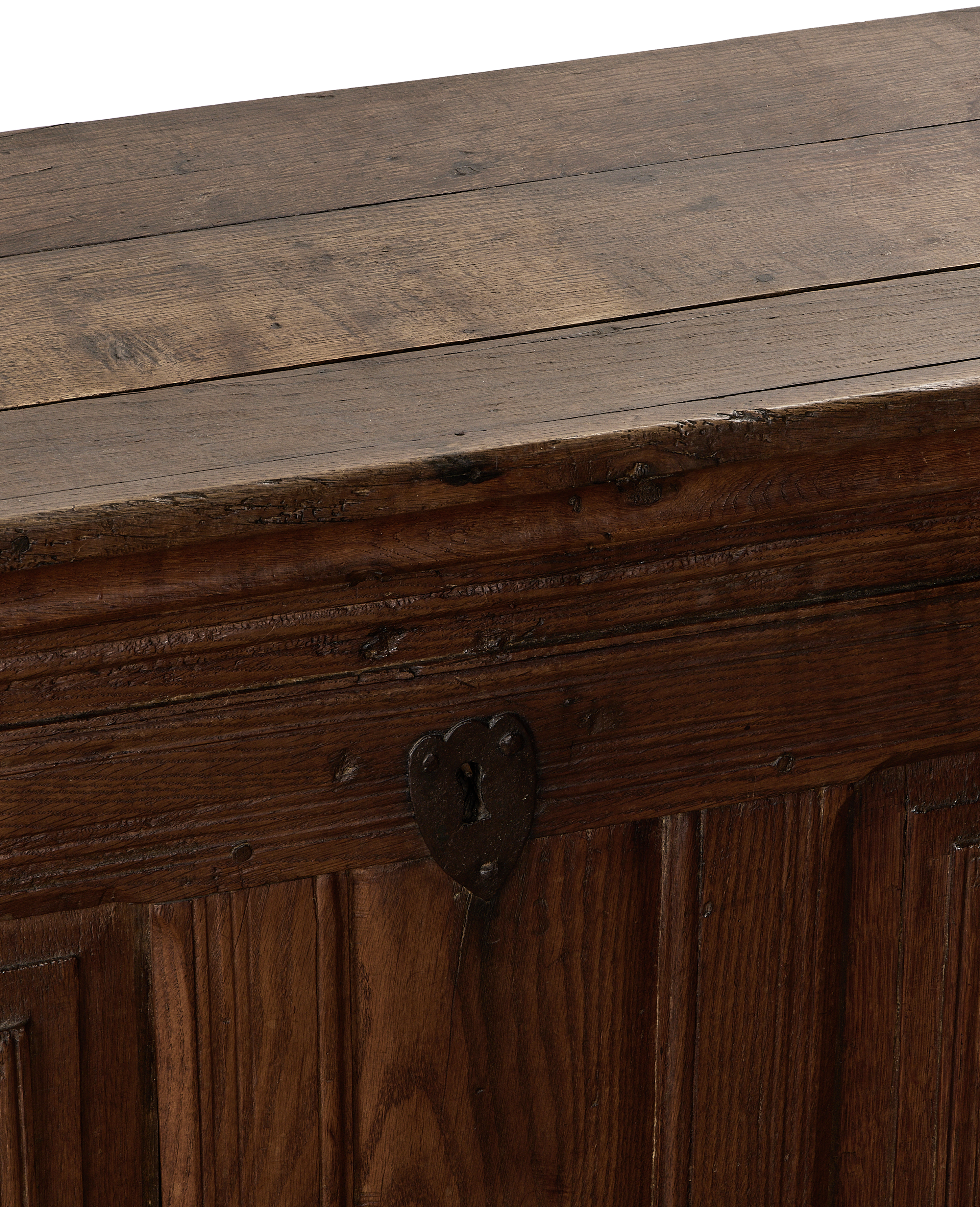 Vintage French oak chest close-up, showing rustic texture, metal keyhole, and planked top.