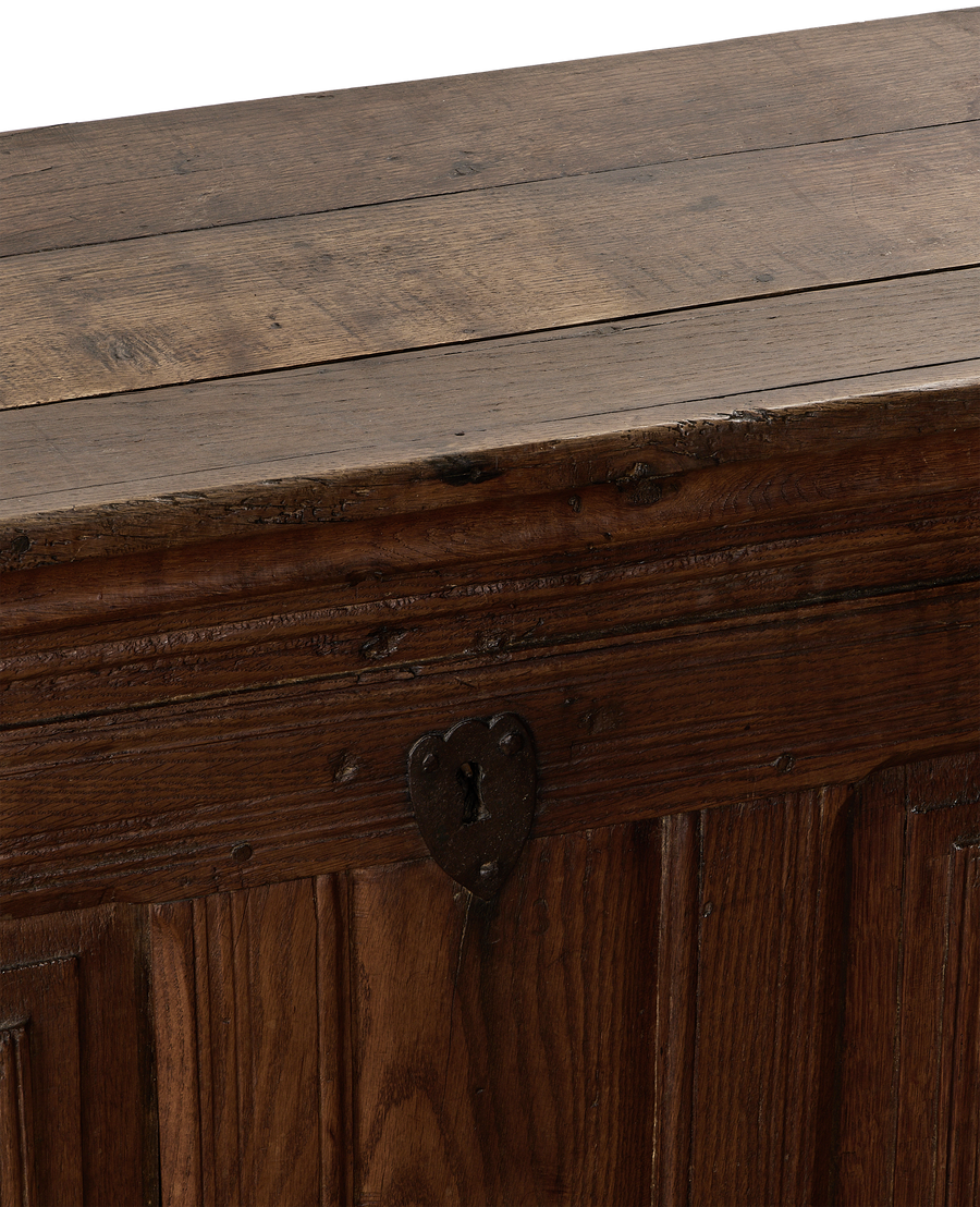 Vintage French oak chest close-up, showing rustic texture, metal keyhole, and planked top.