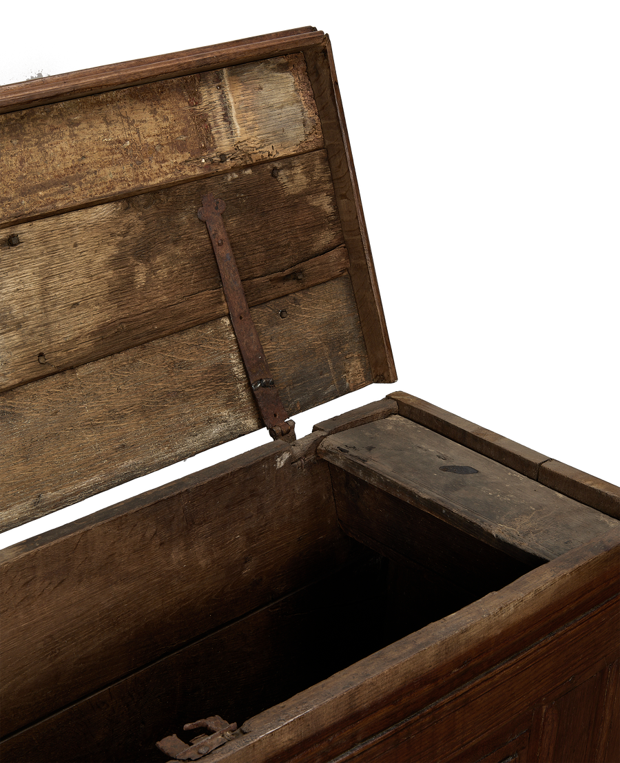 Open vintage French oak wood chest interior, showcasing rustic hinges and aged timber.