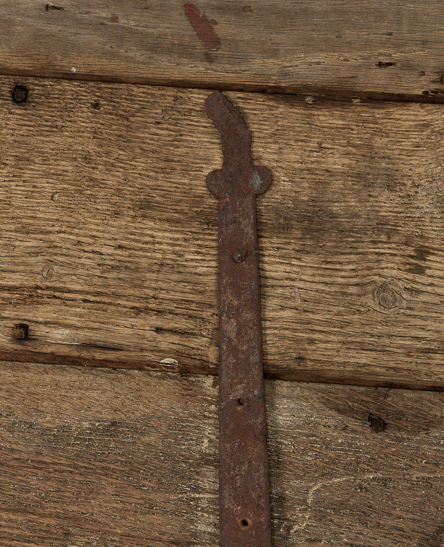 Detail of rustic forged iron hinge and weathered vintage French oak chest planks.