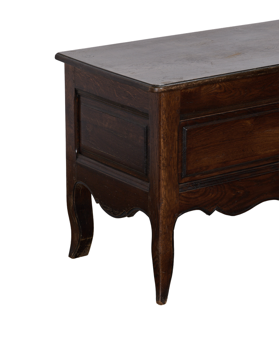 Vintage French oak chest, close up of rustic dark wood grain and decorative scalloped base.