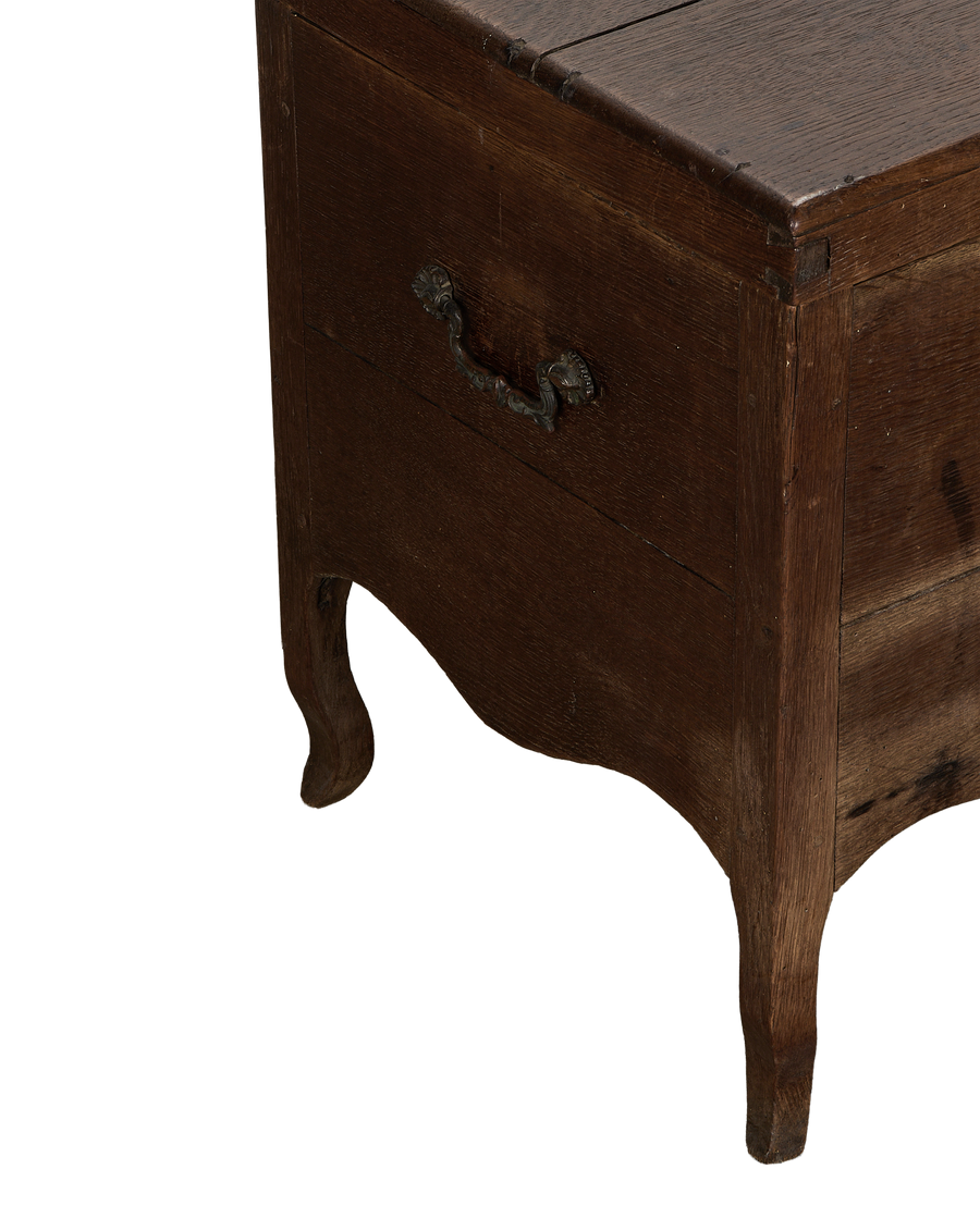 Vintage French oak chest angled close-up, ornate metal handle, and curved leg.