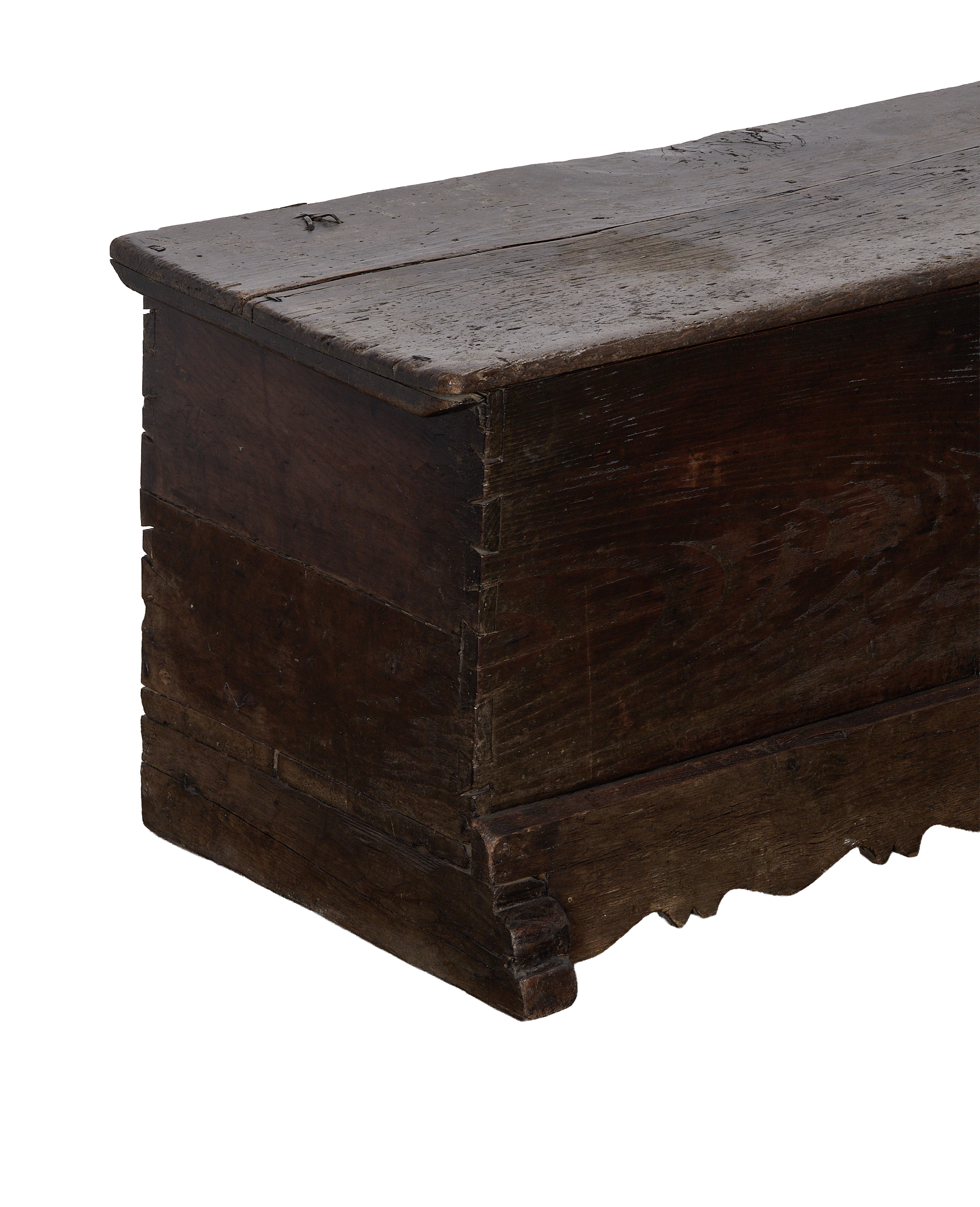 Vintage French oak chest, showing worn dark wood, dovetailed corner, and carved bottom edge.
