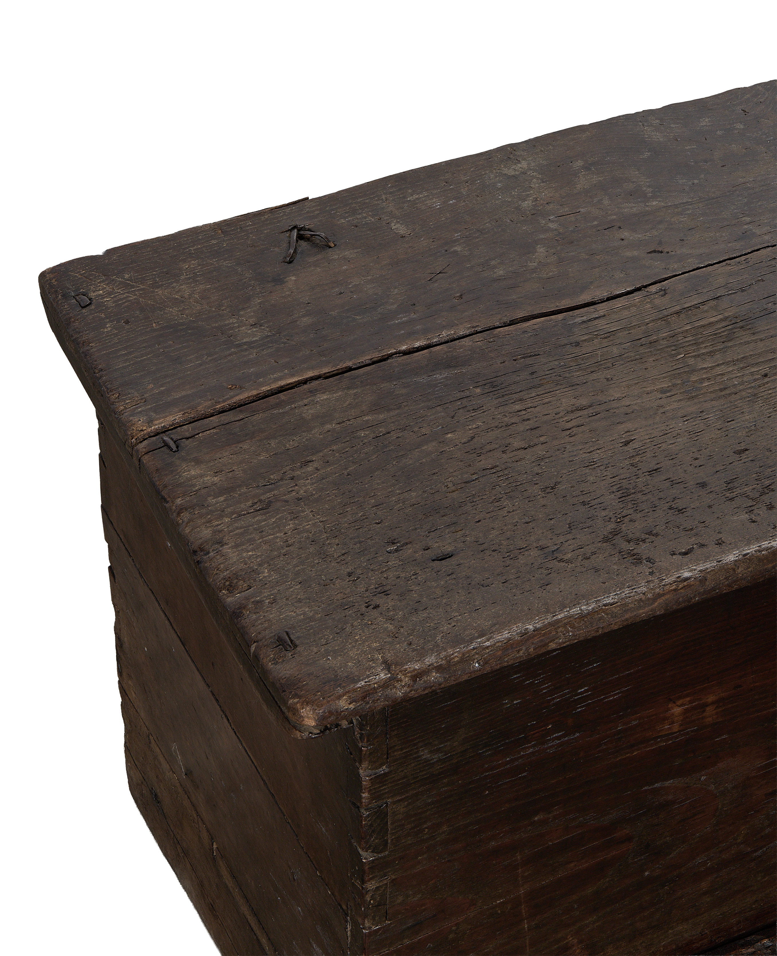 Close up of vintage French oak wood chest lid with distressed texture and visible nails.