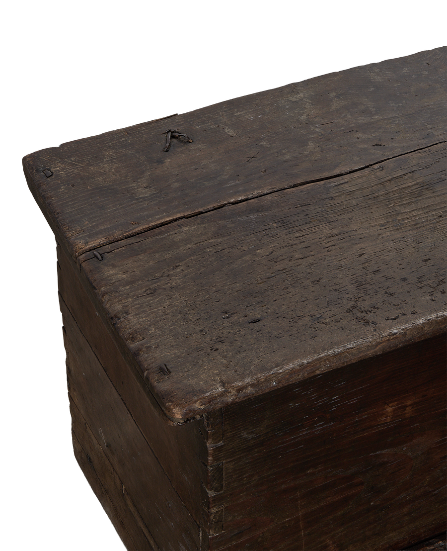 Close up of vintage French oak wood chest lid with distressed texture and visible nails.
