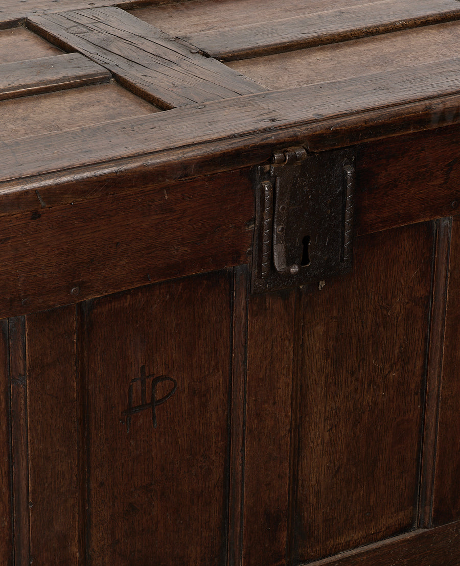 Vintage English oak chest, close-up of dark paneled wooden side and rustic iron lock.