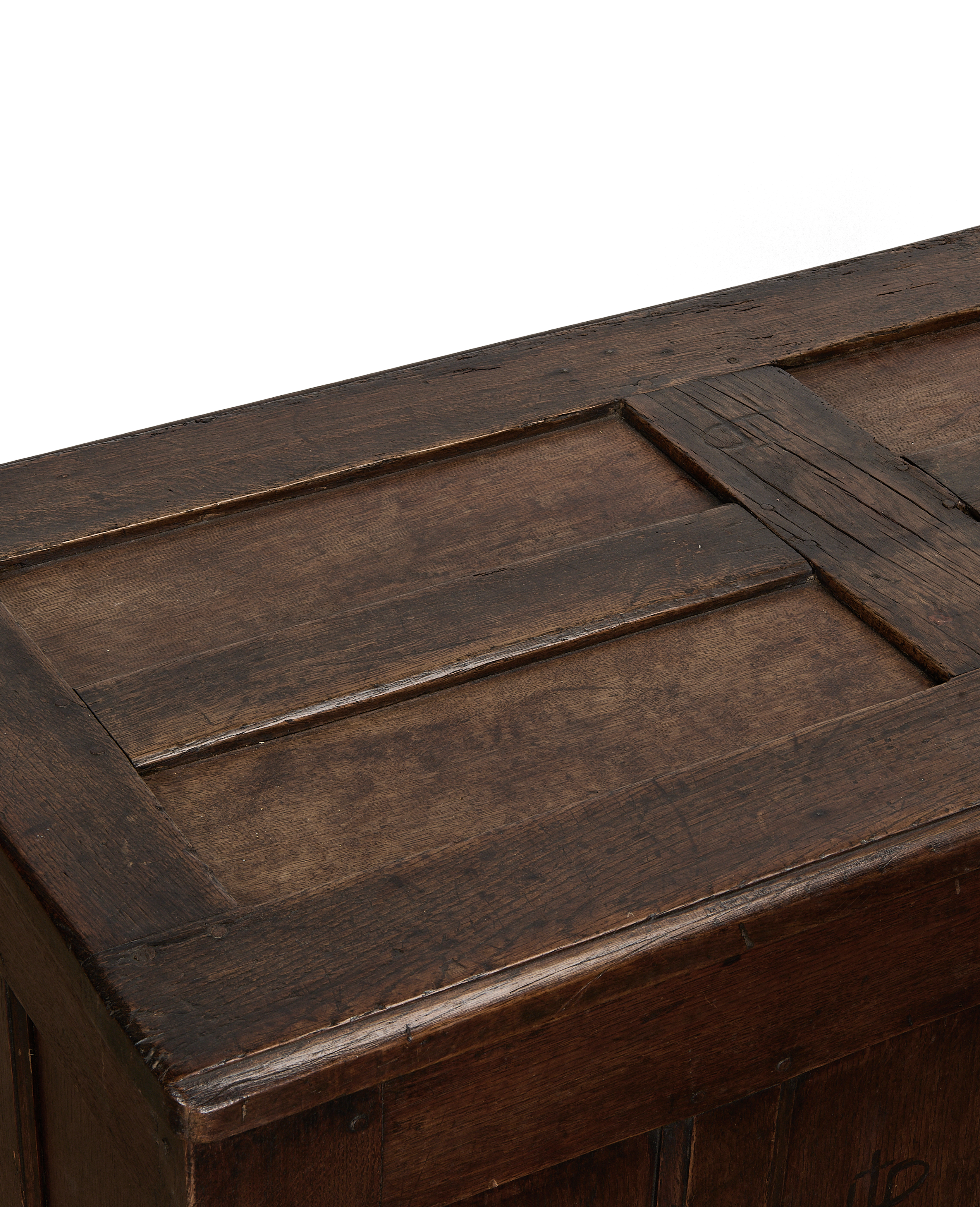 Close-up of vintage French oak trunk lid, showing paneled detail and rich patina.