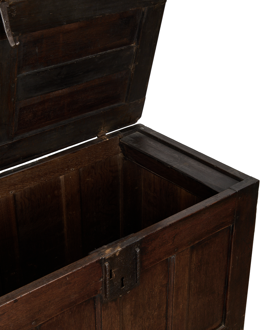 Open vintage dark oak English trunk, showing interior grain and antique iron lock.