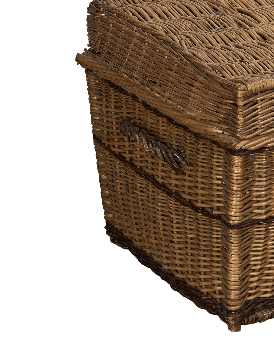 Vintage wicker chest, angled side view, showcasing the woven texture and twisted handle detail.