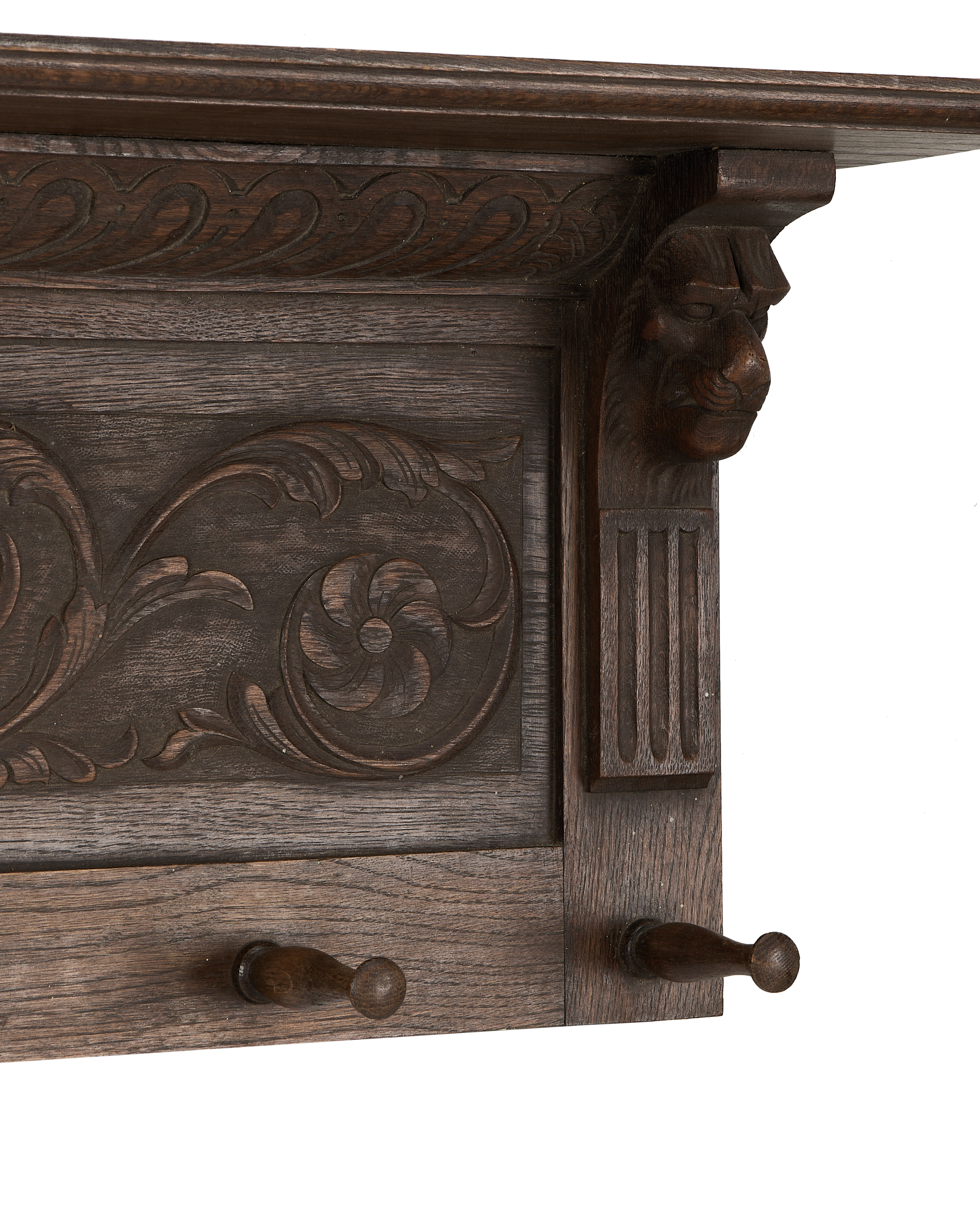 Close-up of vintage French oak hanging shelf, showing ornate lion head carving and details.