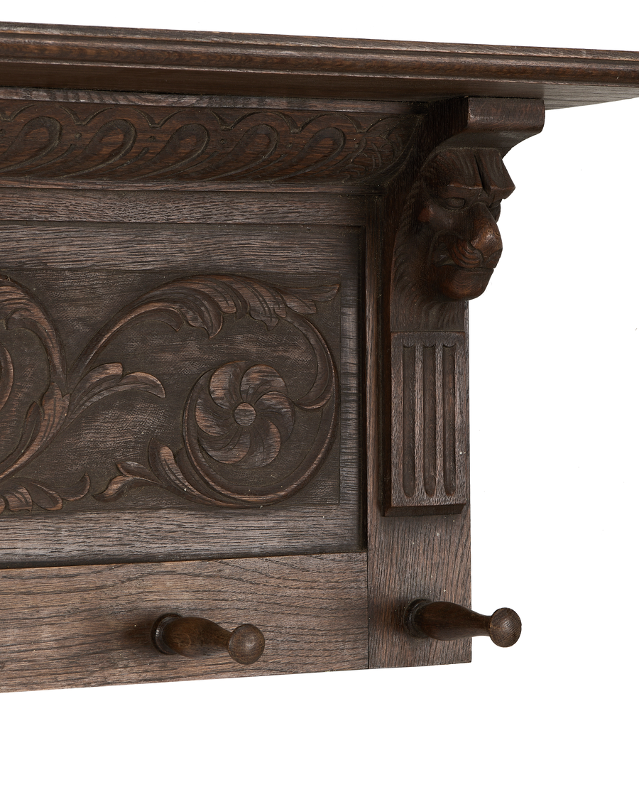 Close-up of vintage French oak hanging shelf, showing ornate lion head carving and details.