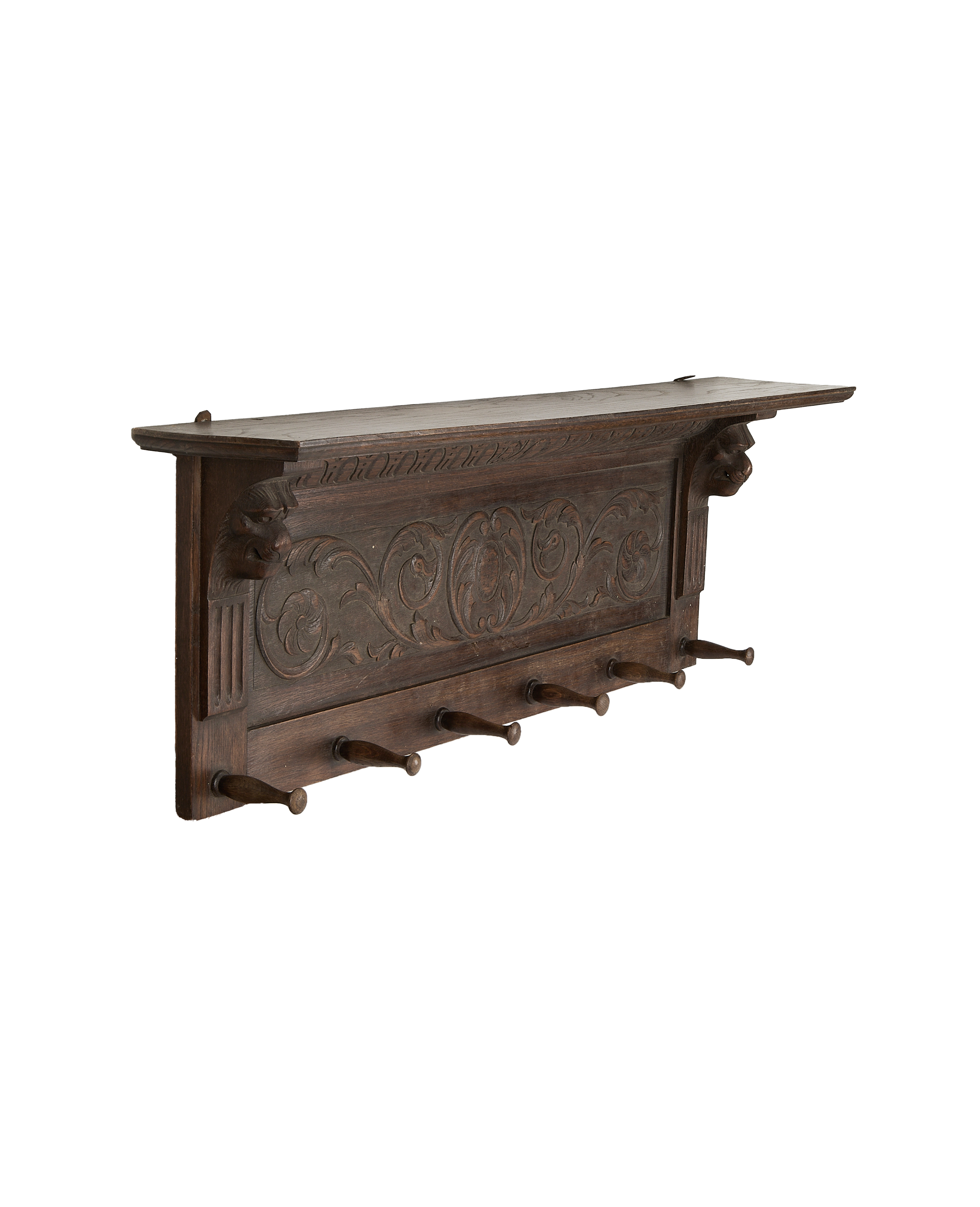 Ornate French vintage oak hanging shelf with six rustic pegs, displaying carved lion heads.