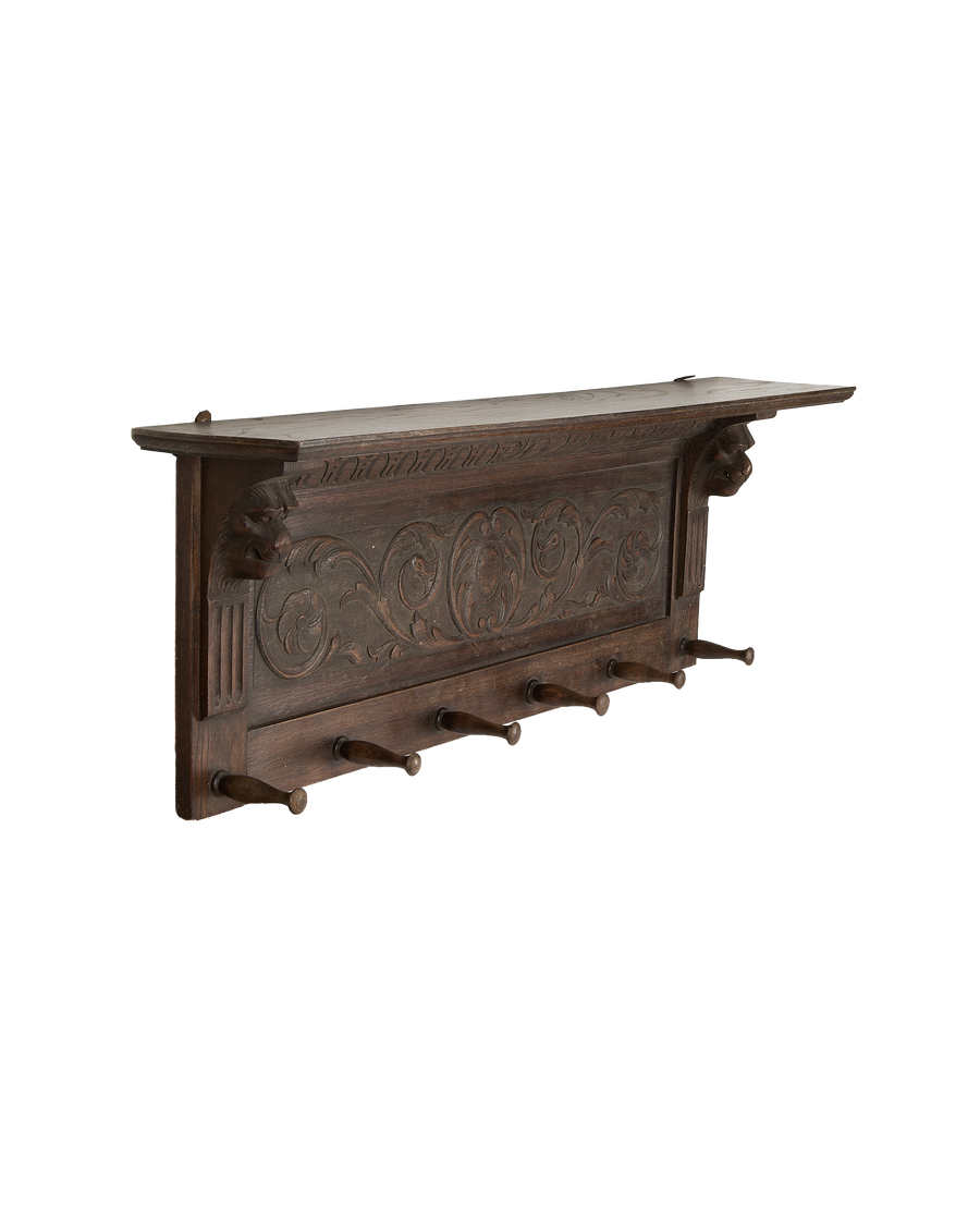 Ornate French vintage oak hanging shelf with six rustic pegs, displaying carved lion heads.
