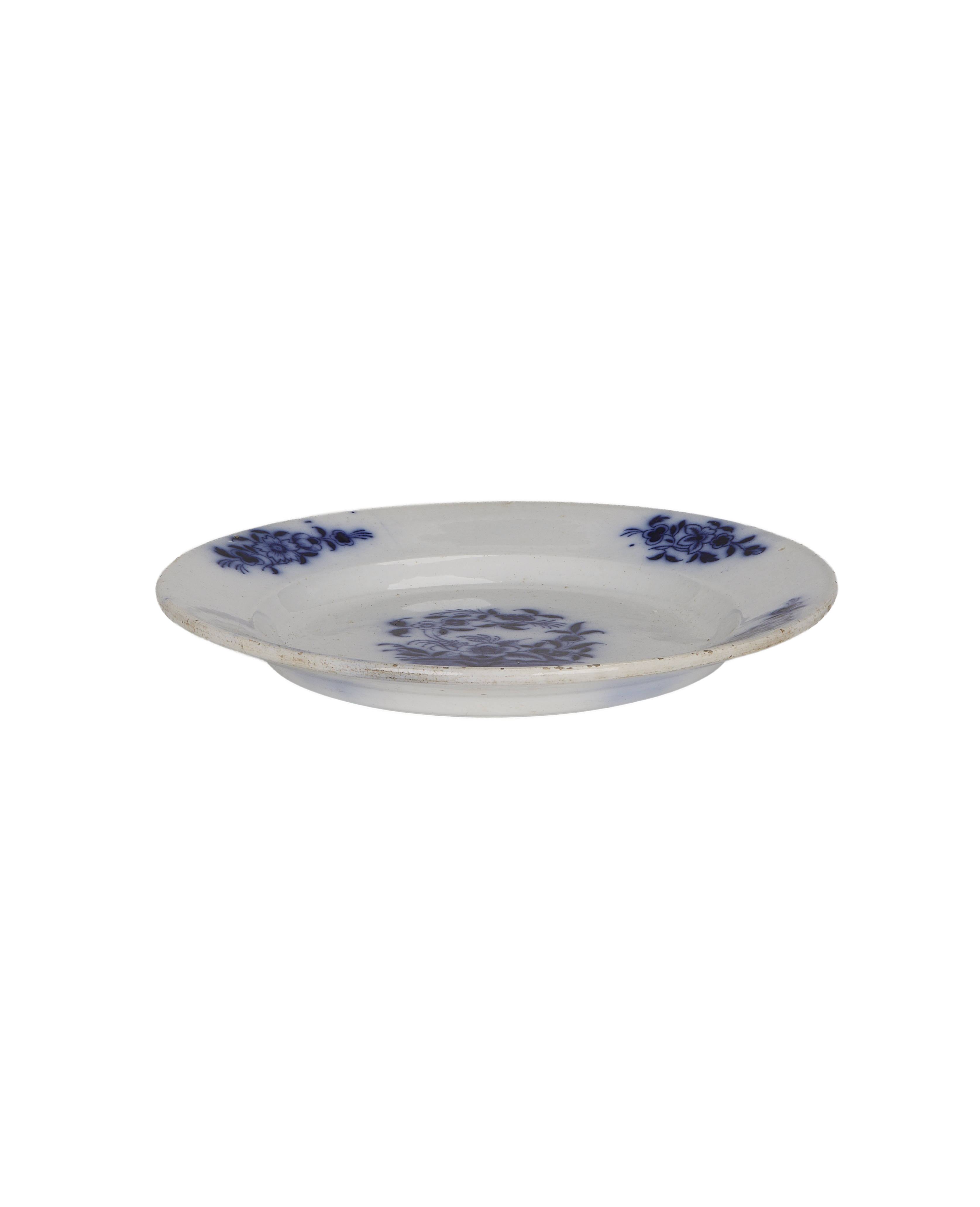 Vintage French white ceramic plate with faded blue floral pattern and rustic distress.