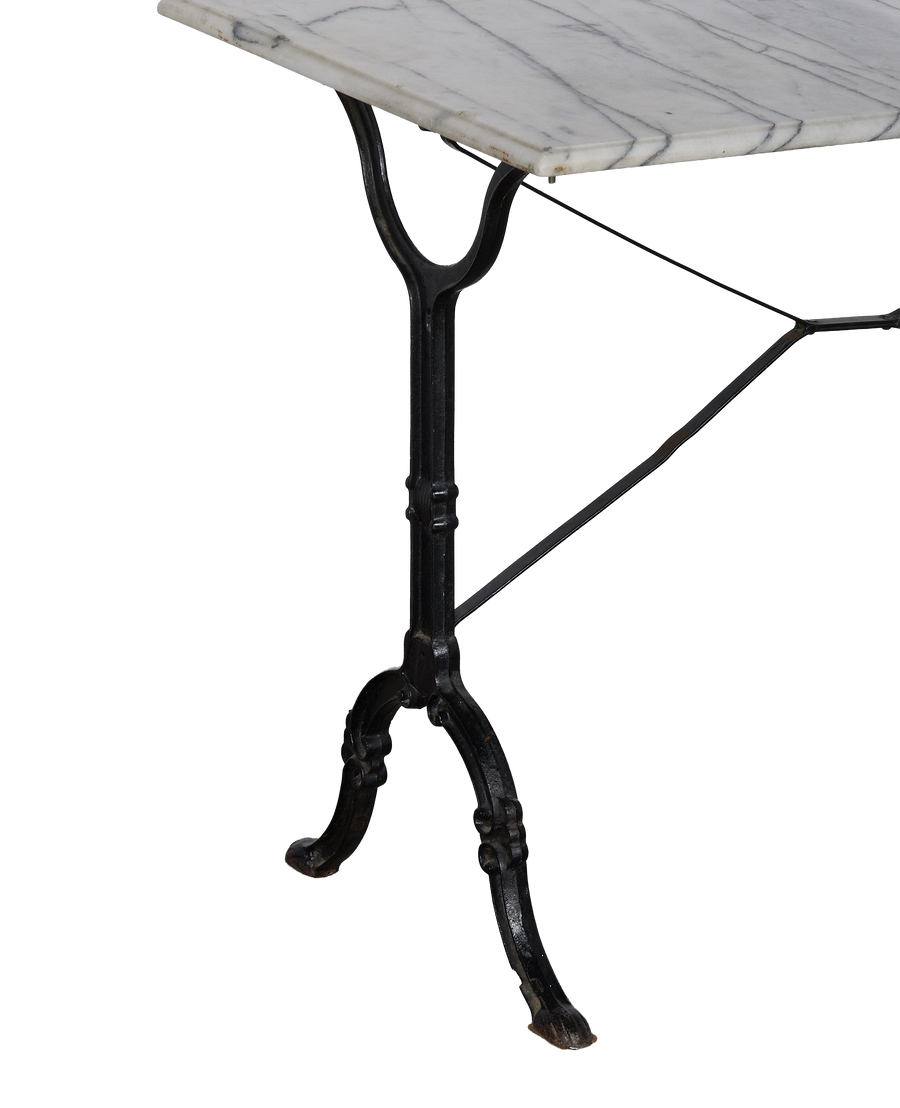 Vintage French marble bistro table with ornate black cast iron base, side view.