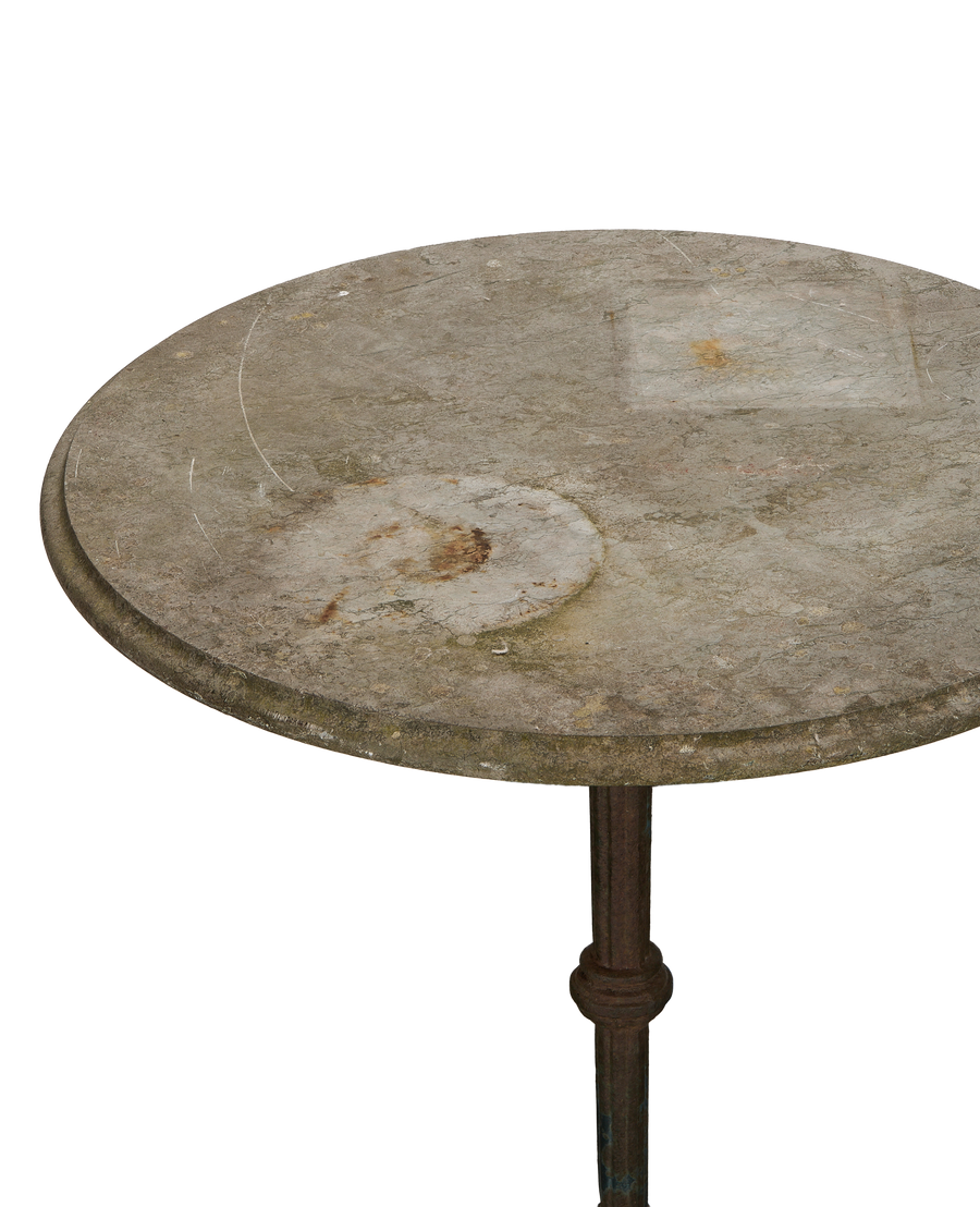 Vintage French bluestone bistro table, close-up top view showing weathered surface and base.