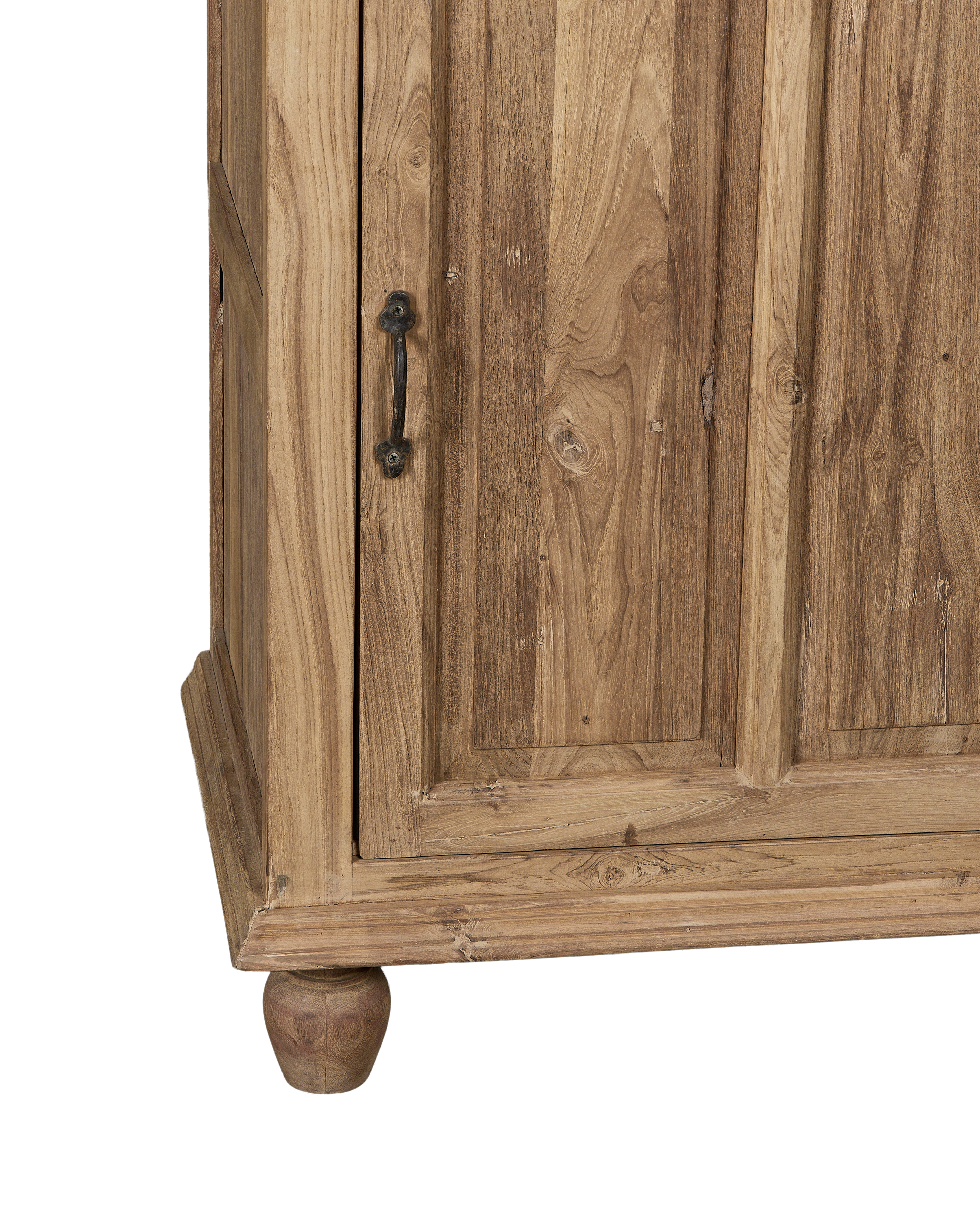 Close-up of vintage bleached oak cabinet corner, showing ornate handle and turned foot.