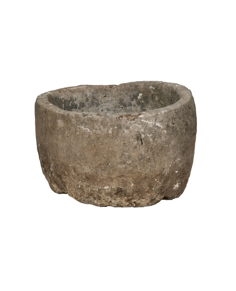 Vintage round Indonesian limestone trough, showing rough exterior texture and chipped rim.