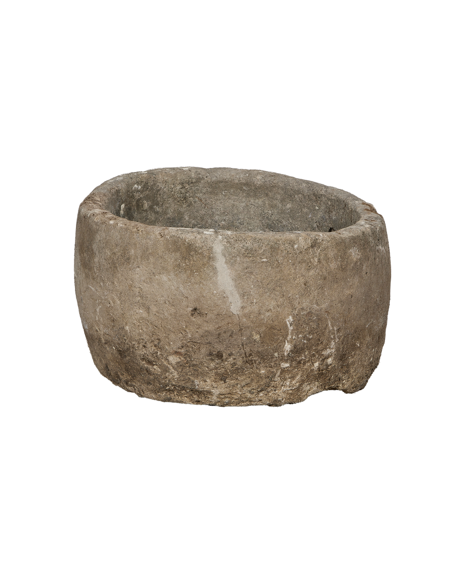 Vintage Indonesian limestone trough, round, showing weathered gray-brown rough texture and patina.