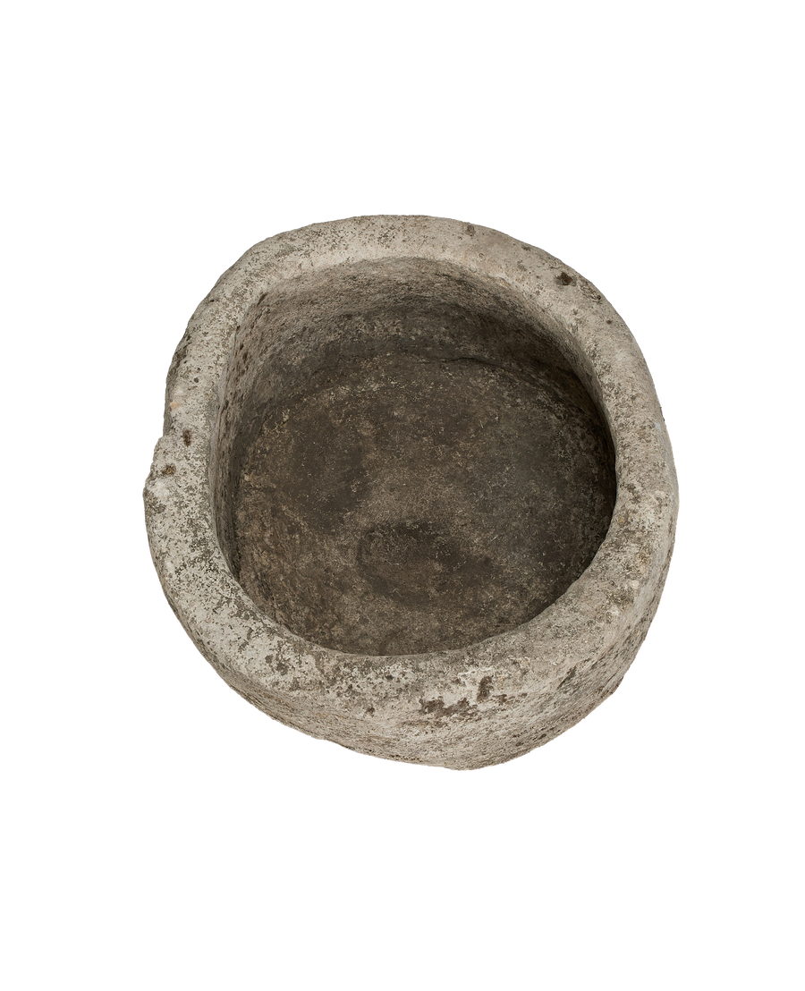 Vintage round Indonesian limestone trough, showing weathered interior basin from top angle.