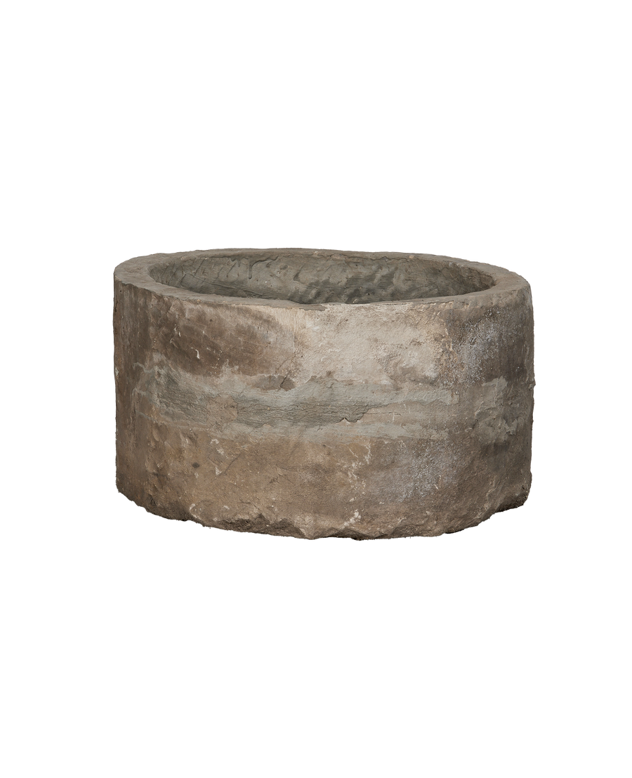 Vintage Indonesian round limestone trough, close-up interior and exterior texture.