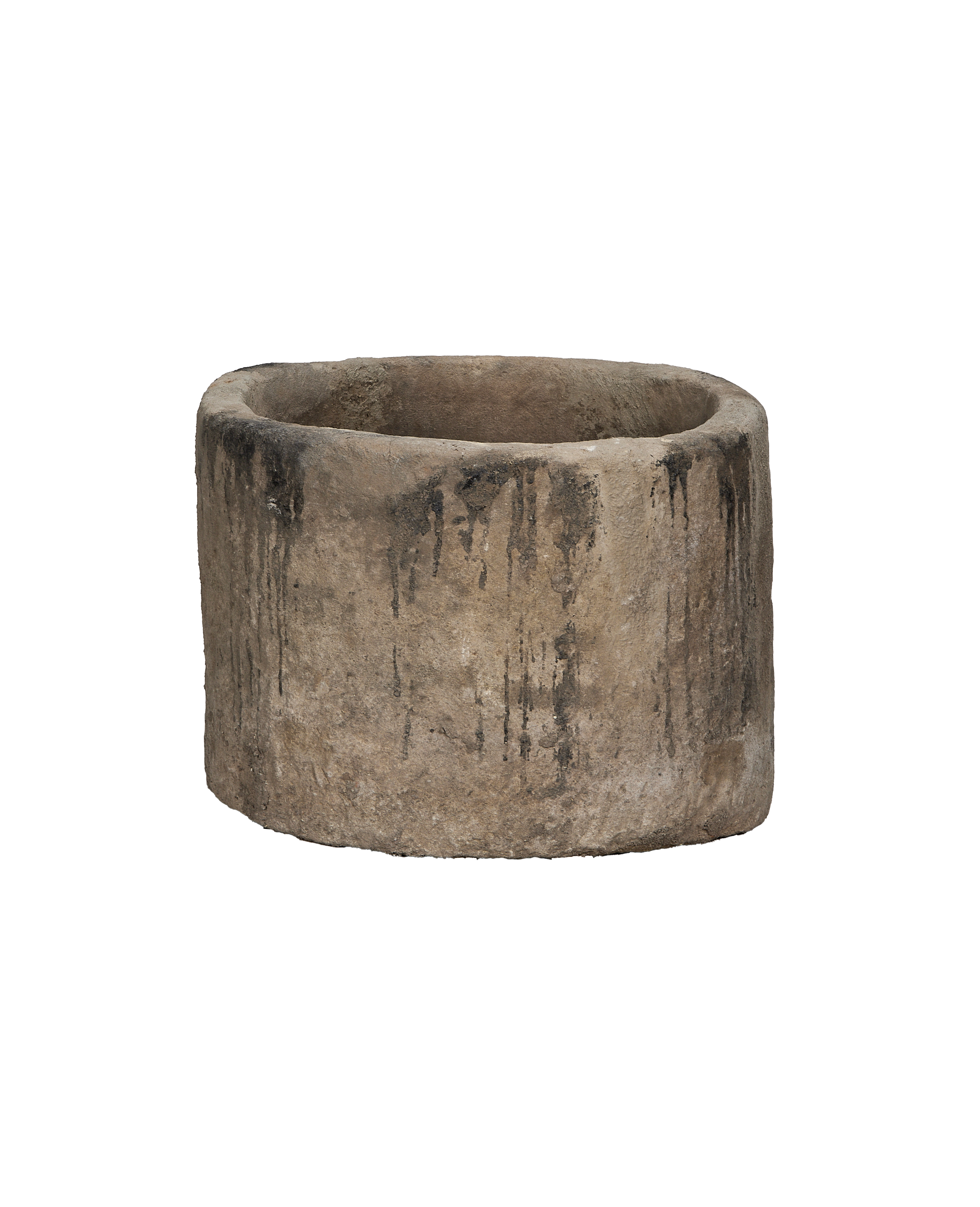 Vintage round Indonesian limestone trough from a side angle, revealing weathered texture and dark stains.