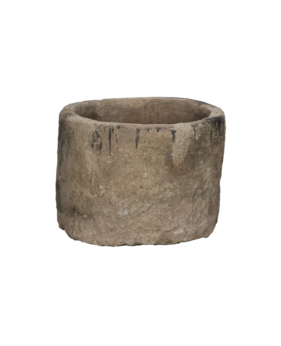 Vintage Indonesian round limestone trough, showing weathered texture and dark stains on rim.